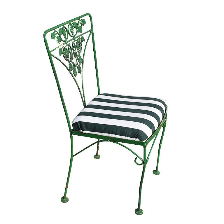 Transport yourself to the Polo Lounge of the Beverly Hilton with this set of four green fruit motif garden chairs. Each chair is painted in rustic kelly green paint and features a green and white stripe cushion with a wood bottom. Each chair back is