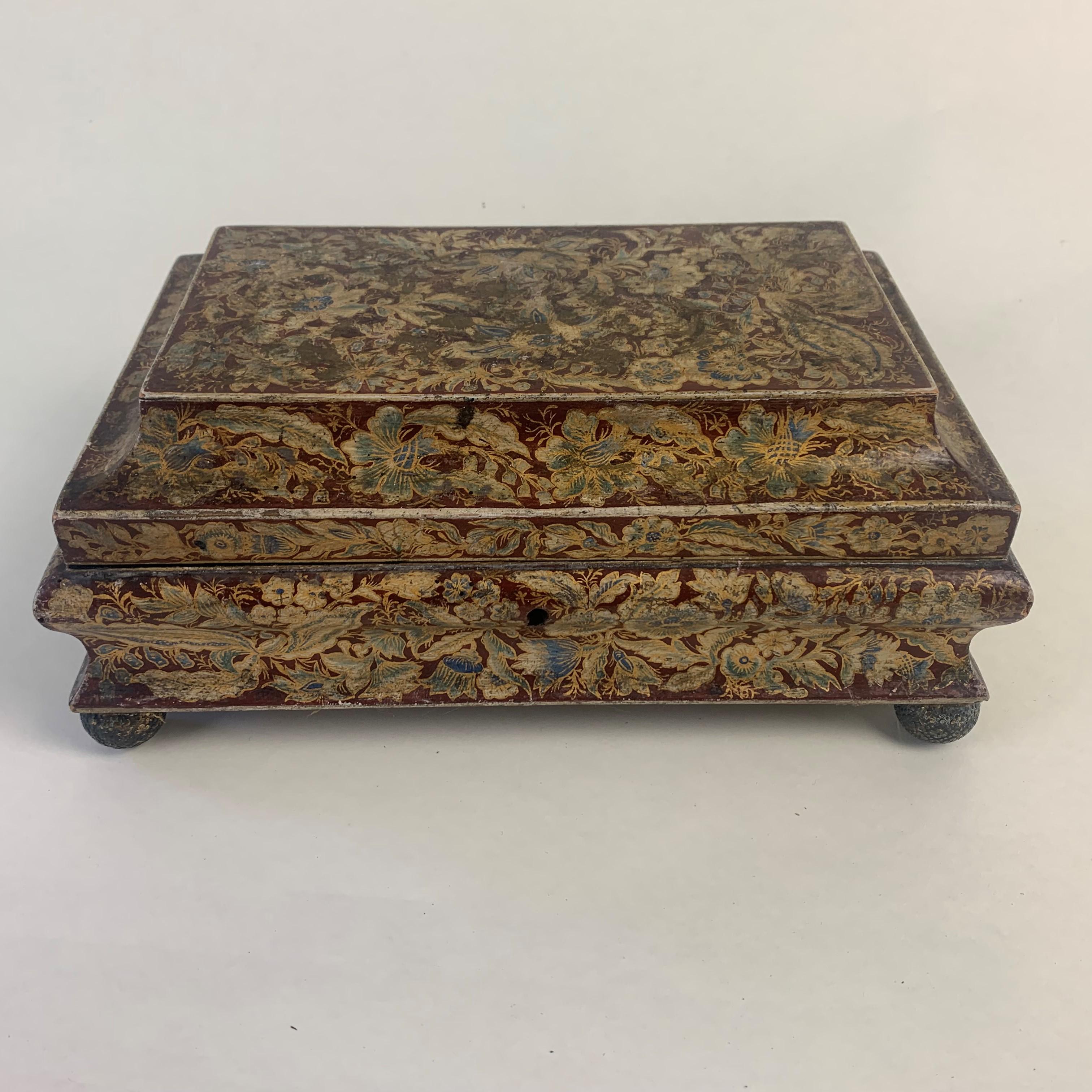 Superb quality Regency period hand painted card box of shaped form, profusely decorated all over with gold and blue leaves and flowers on a scarlet ground and standing on gold ball feet. The interior lined with the original green sugar paper with