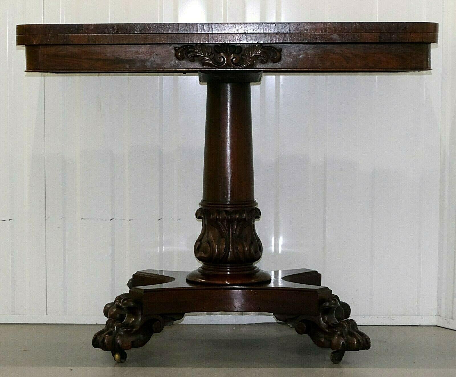 We are delighted to offer for sale this stunning Regency hardwood 19th century card table.

Twist and lift the top to reveal a blue lined round surface. The table is standing on beautiful paw feet that have casters underneath. The item is in good