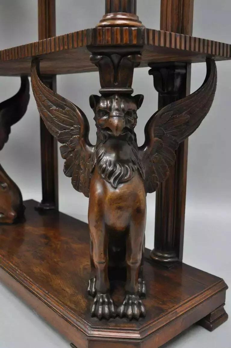 Pareja de Soportes Curio Librería Grifo Tallados de Caoba Estilo Regencia al Estilo Horner. El artículo presenta grifos alados de figura completa finamente detallados, galería tallada con perforaciones, soportes de columna, hermosas vetas de madera