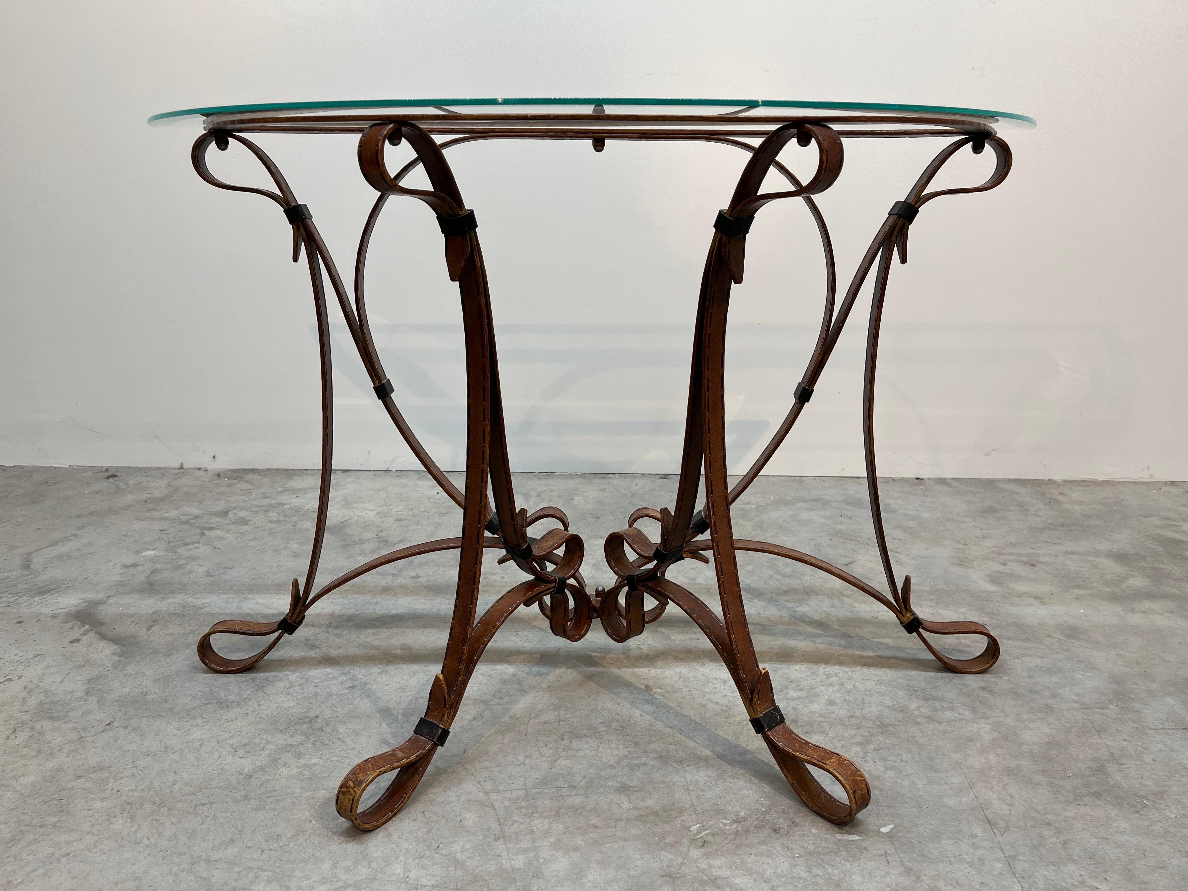 A beautiful Demi-Lune console table attributed to Jacques Adnet having faux leather strap scrolled iron frame with beveled glass top circa 1970. Solid iron construction with sturdy frame and wonderful details.