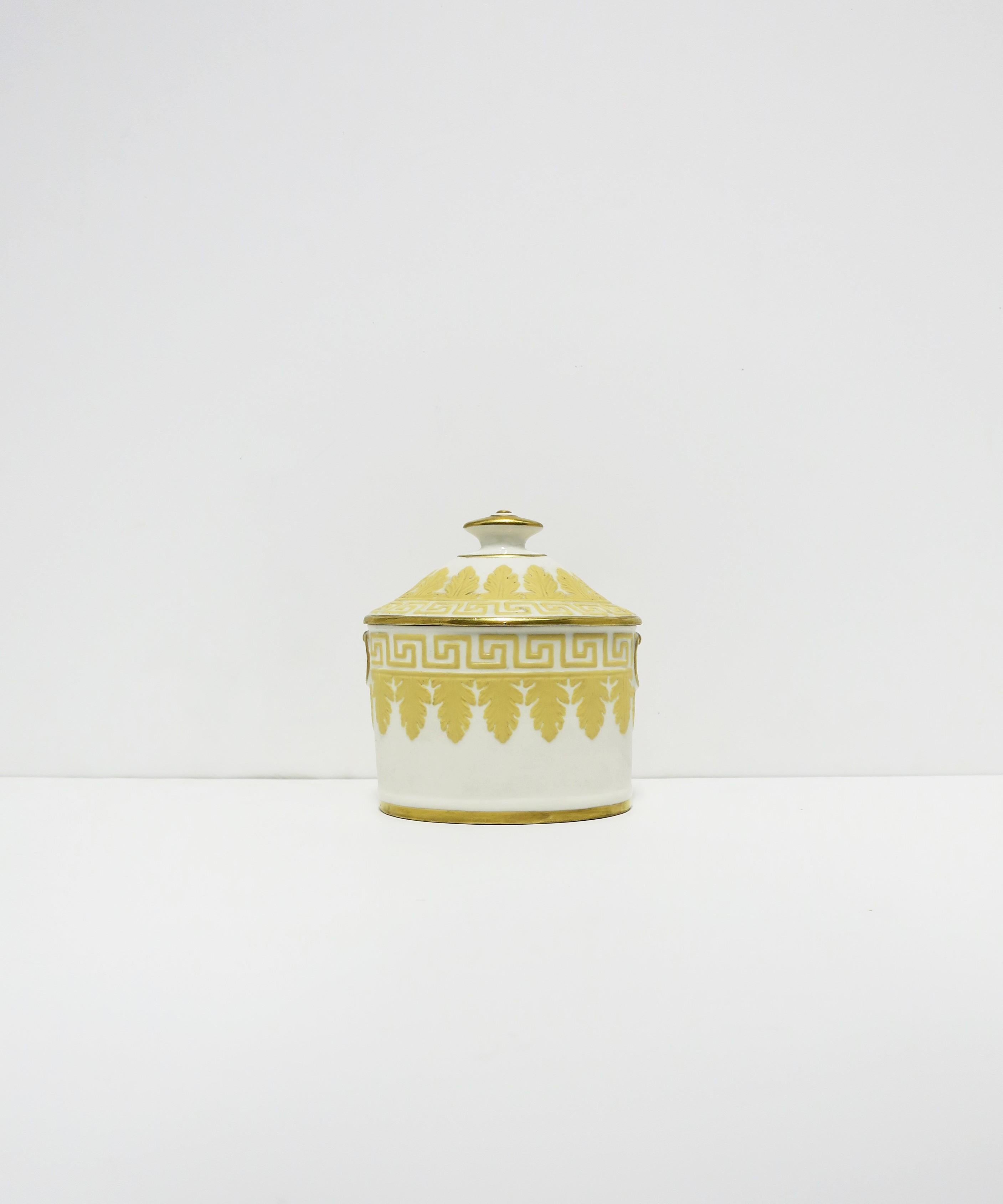 A beautiful English jasperware box with acanthus leaf and Greek-Key design, circa late-19th century, England. Piece is attributed to Wedgwood and designer, John Flaxman. Box is oval, matte (unglazed), with a yellow raised frieze of Greek-Key and