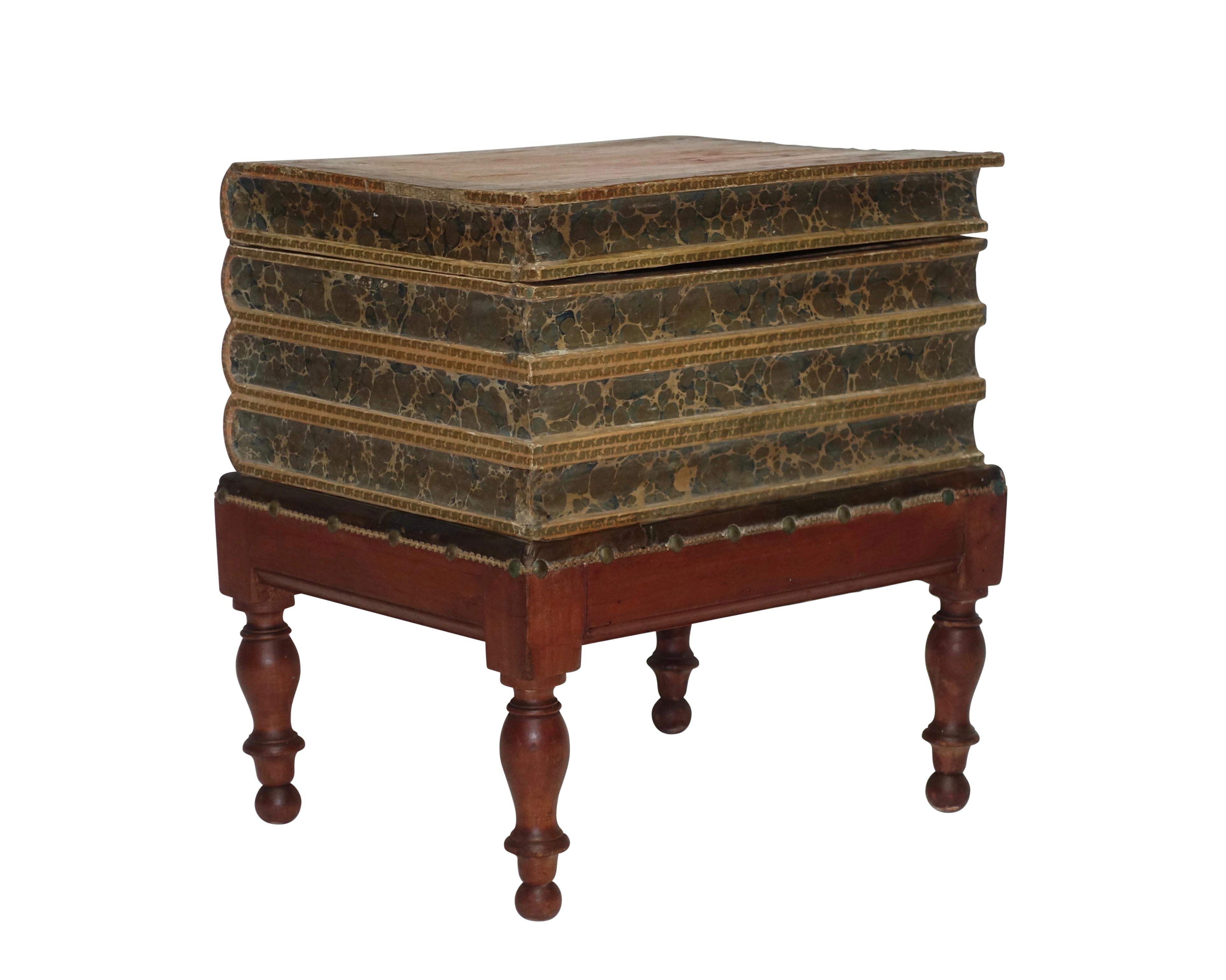 Leather four volume faux book box on painted pine stand with turned legs. Interior of the box lined with Italian marbleized paper and having a small lidded compartment within. England, early to mid-19th century.