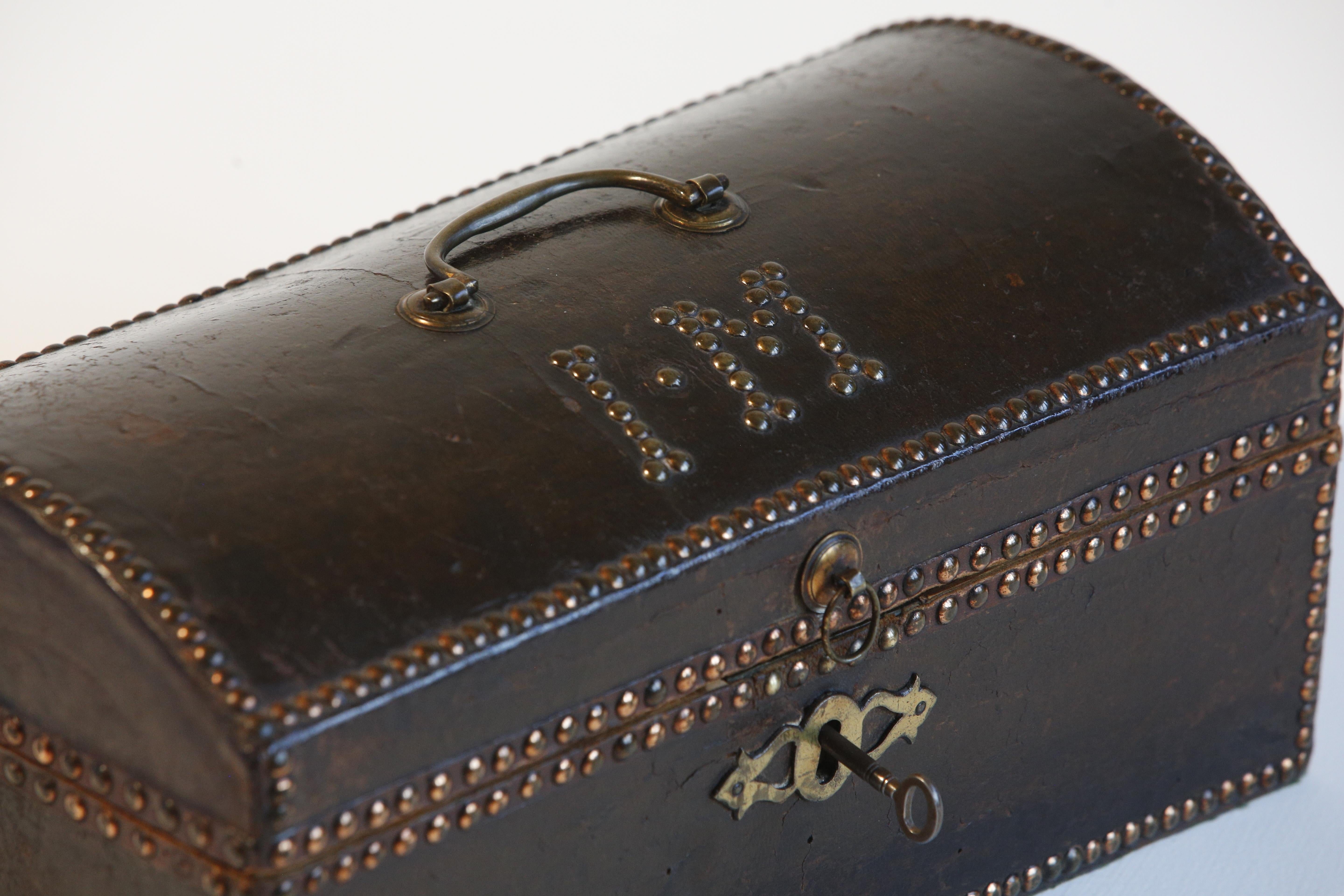 Regency leather studded traveling case by Chapple & Sons of Cheapside London with studded brass initials ( I * M )

This compact Regency trunk is constructed from black leather on a pine carcass and is adorned with numerous brass dome-topped studs.