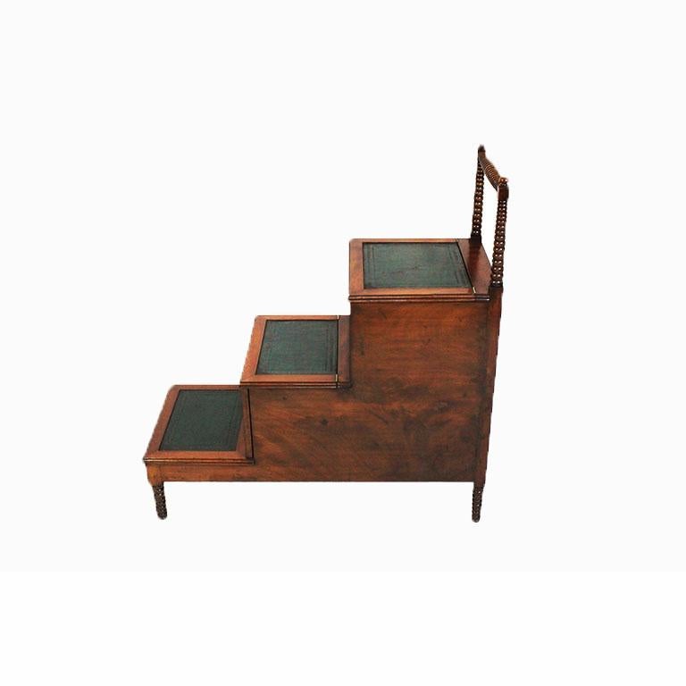 Regency mahogany library steps with top stair compartment with lift top and second step with slide out compartment. Treads finished with green tooled leather.