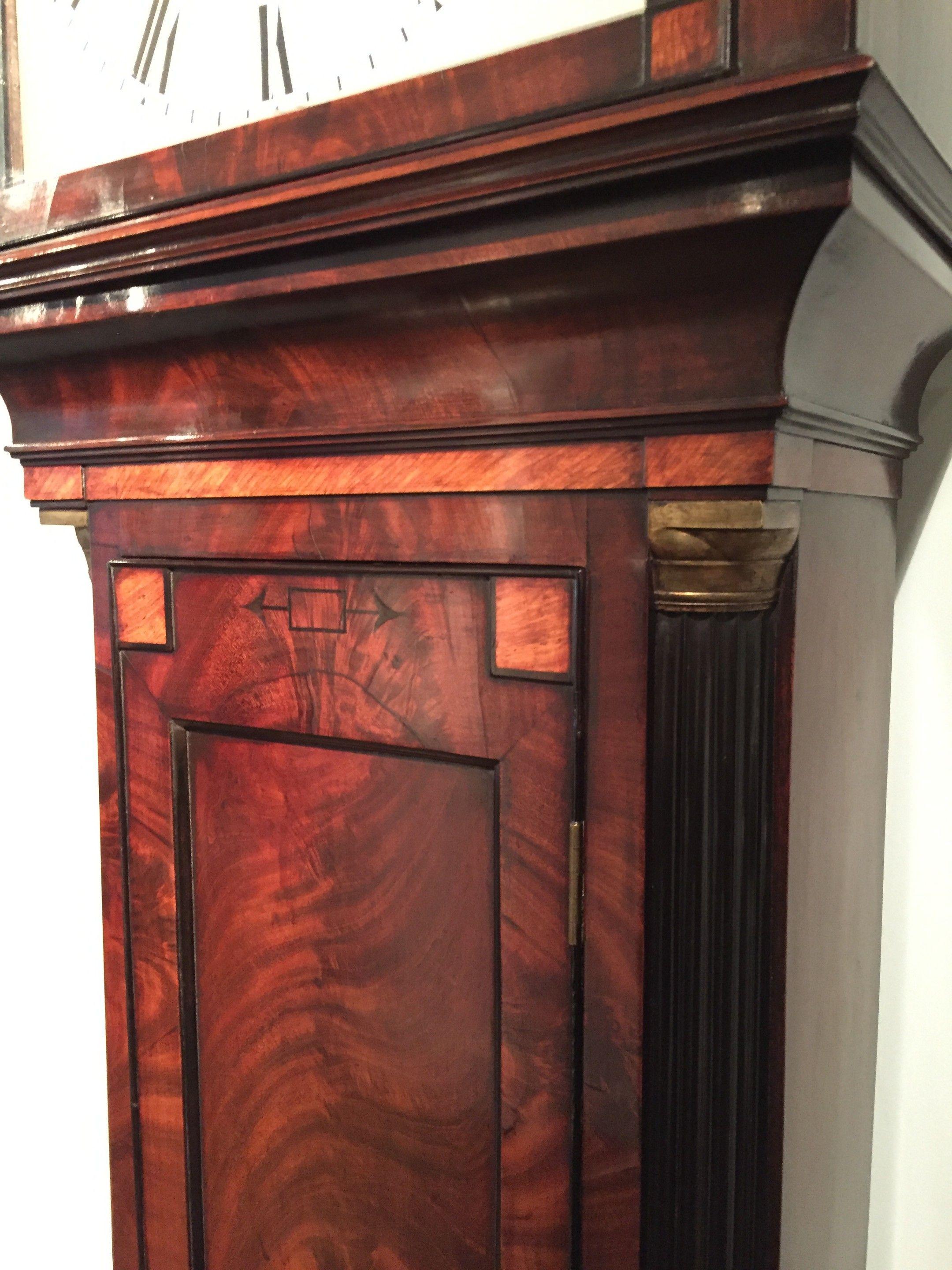 A fine Regency longcase clock in the form of a domestic regulator in an architectural mahogany case with inset panels of satinwood and ebonized mouldings. The case of this clock shows the distinct influence of Thomas Hope, the eminent antiquarian