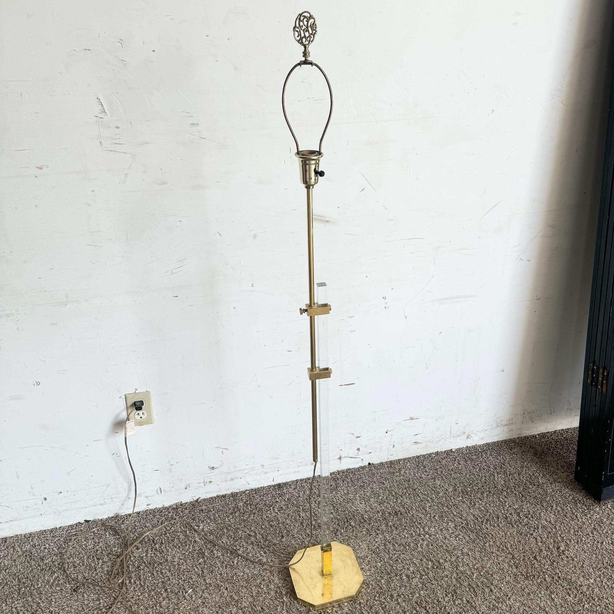 Questa lampada da terra Regency in lucite e oro emana un'eleganza senza tempo grazie alla sofisticata combinazione di lucite trasparente e accenti dorati. Il design elegante e i dettagli lussuosi lo rendono un pezzo forte perfetto per gli interni