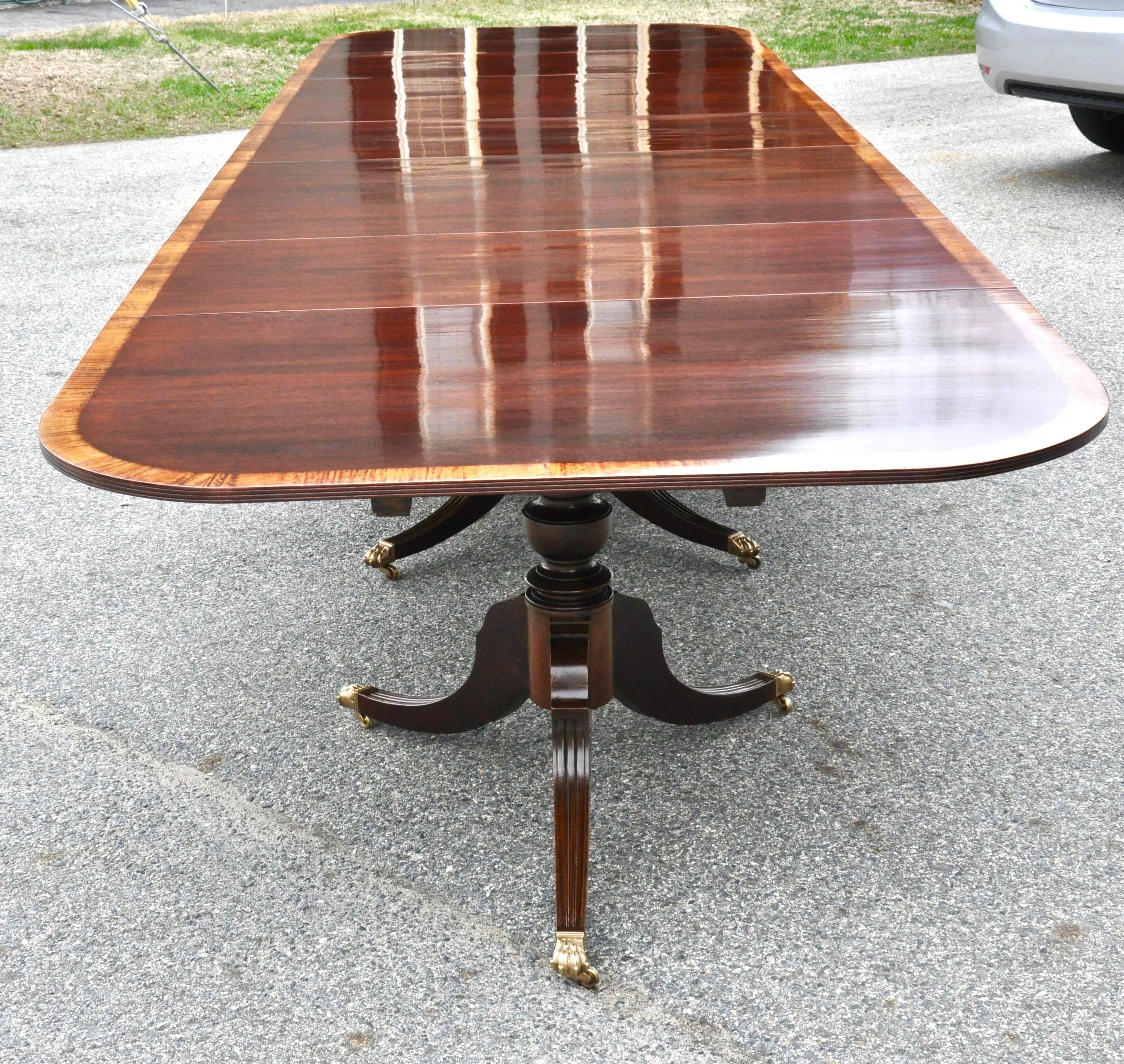 Magnificent large scale Regency style solid mahogany four-pedestal dining table

Nicely figured solid mahogany boards, four sections with beautifully reeded pedestals and three original additional leaves. Satinwood banding. Brass lion paw casters.