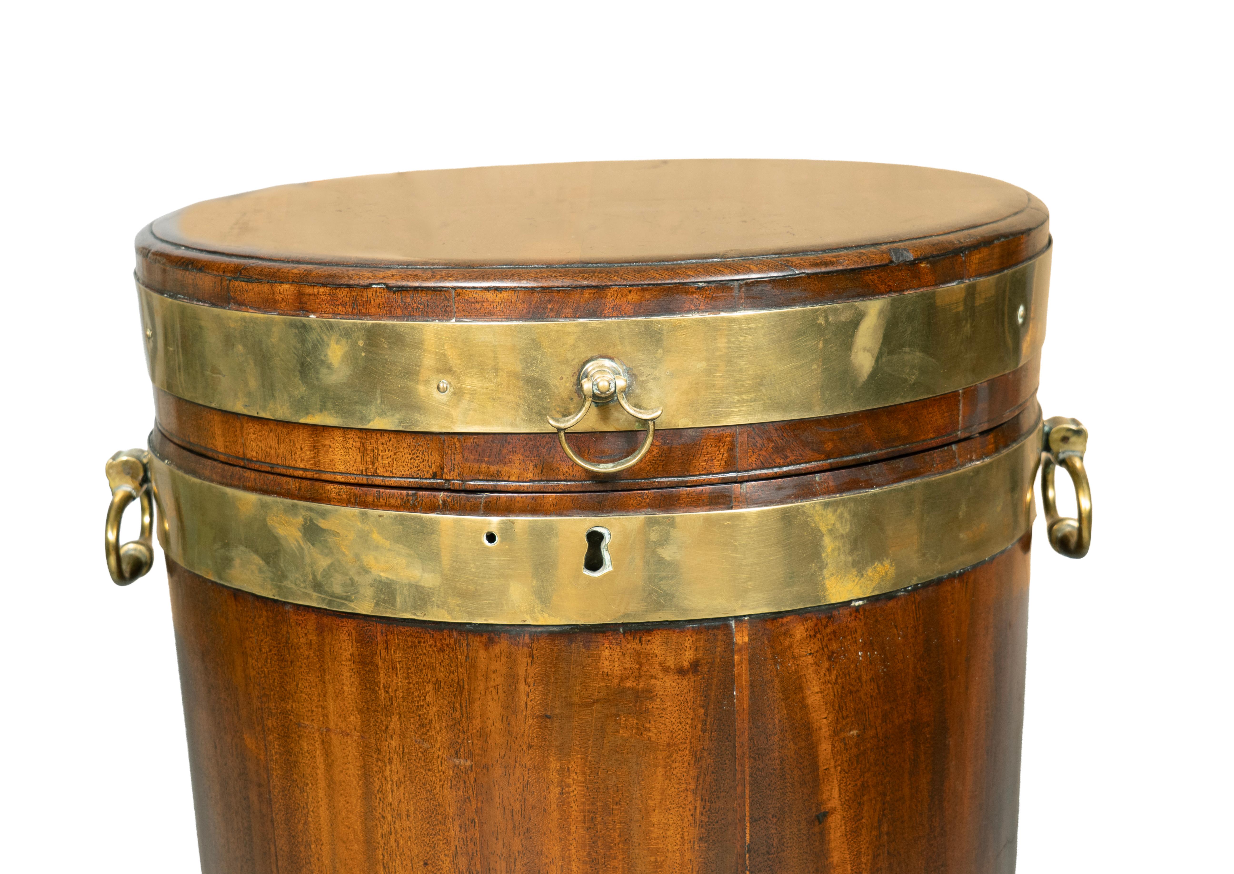 Cylindrique avec couvercle à charnière et section de caisse conforme avec cerclage en laiton et poignées en anneau. Roulettes.