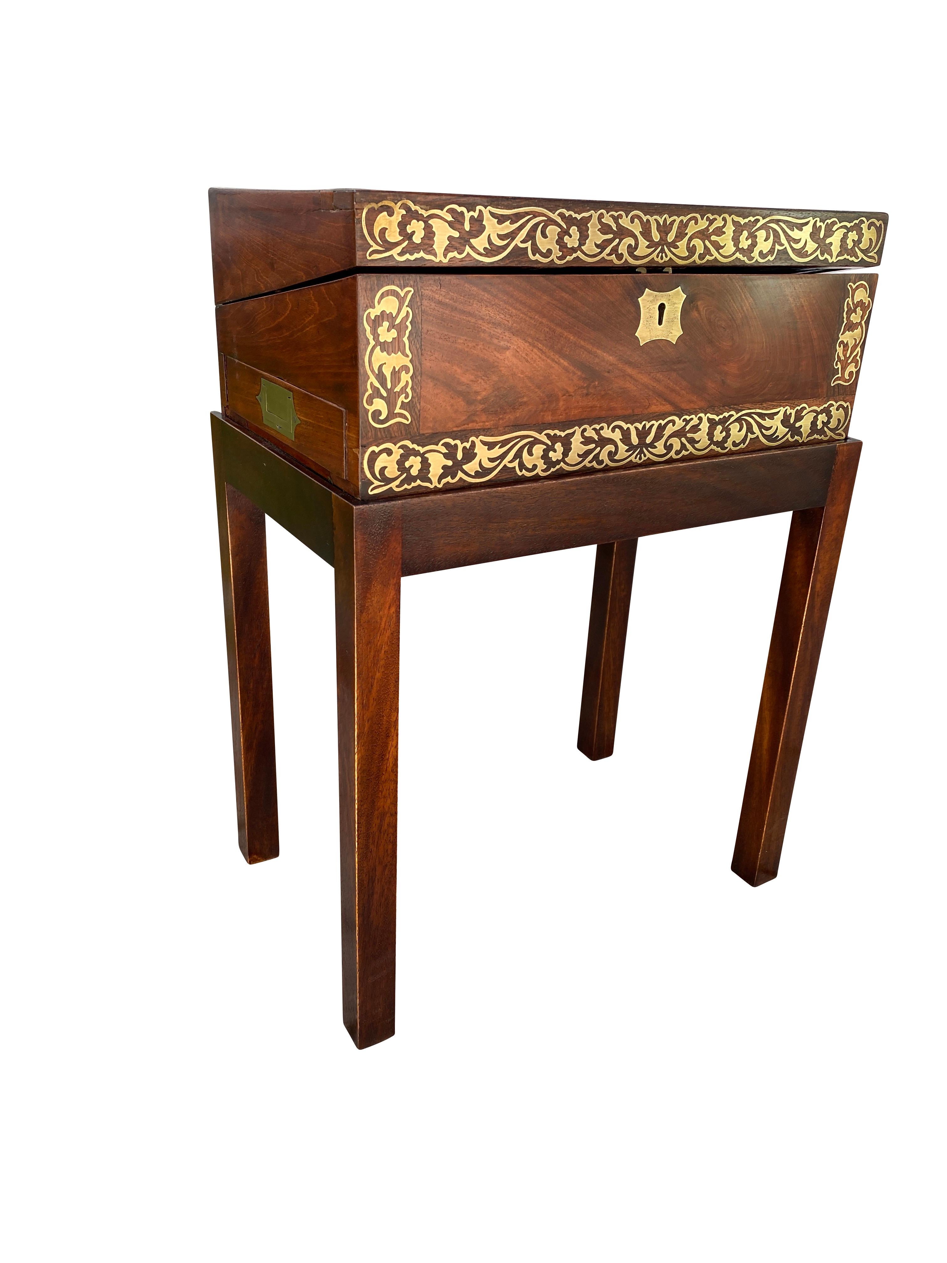 In fine condition with brass inlaid banded hinged top and fitted interior, side drawer; sides similarly decorated and raised on a base with square section legs.