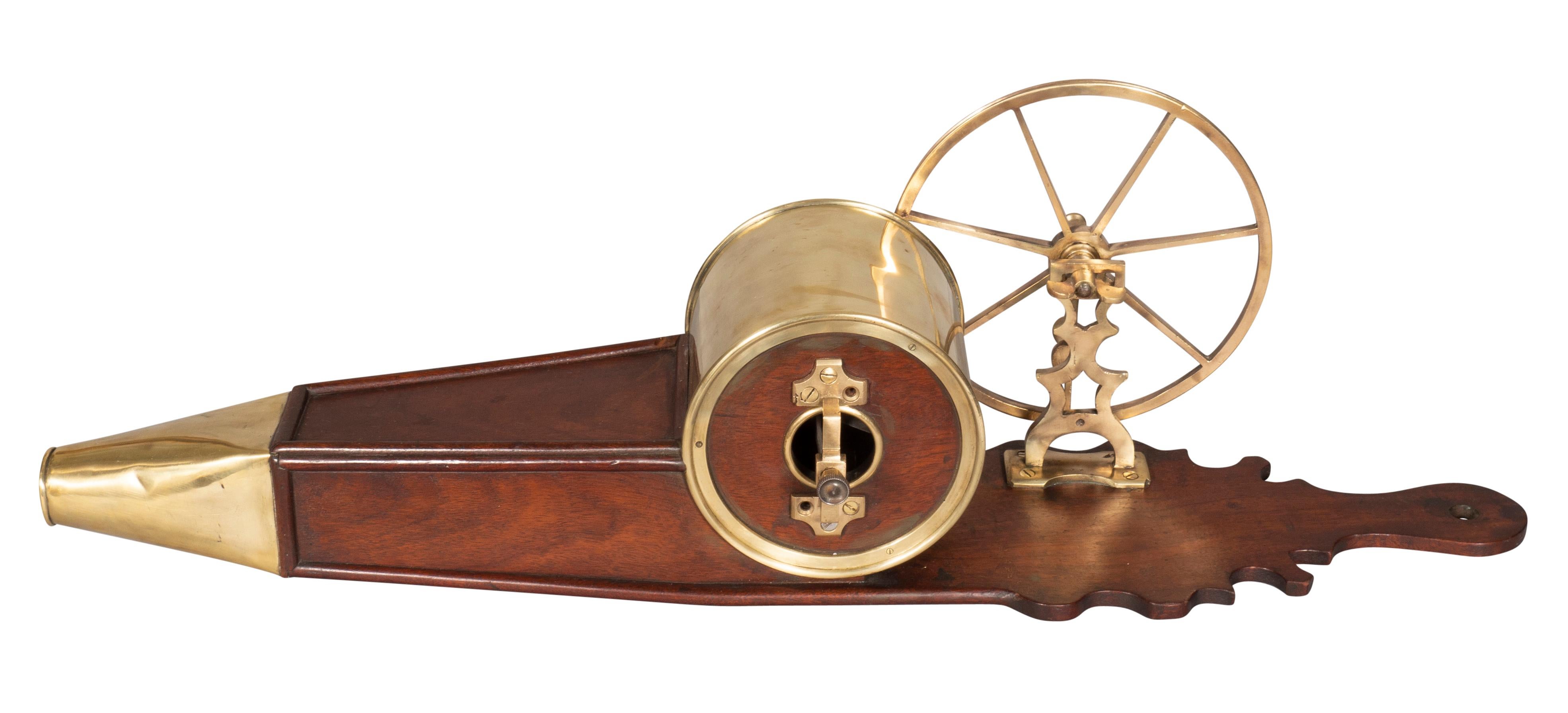 With a cutout for hanging on a wall. Brass spoked wheel with handle that turns to blow air on a fire. Polished.