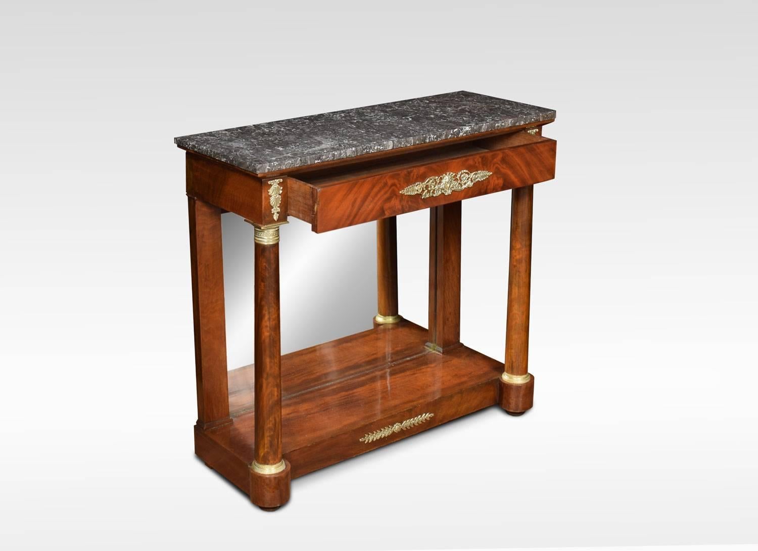 Regency mahogany and gilt metal mounted console table, the grey and white rectangular marble top above a single frieze drawer, raised on column supports with gilt metal capitals. The table having mirrored back, raised on plinth