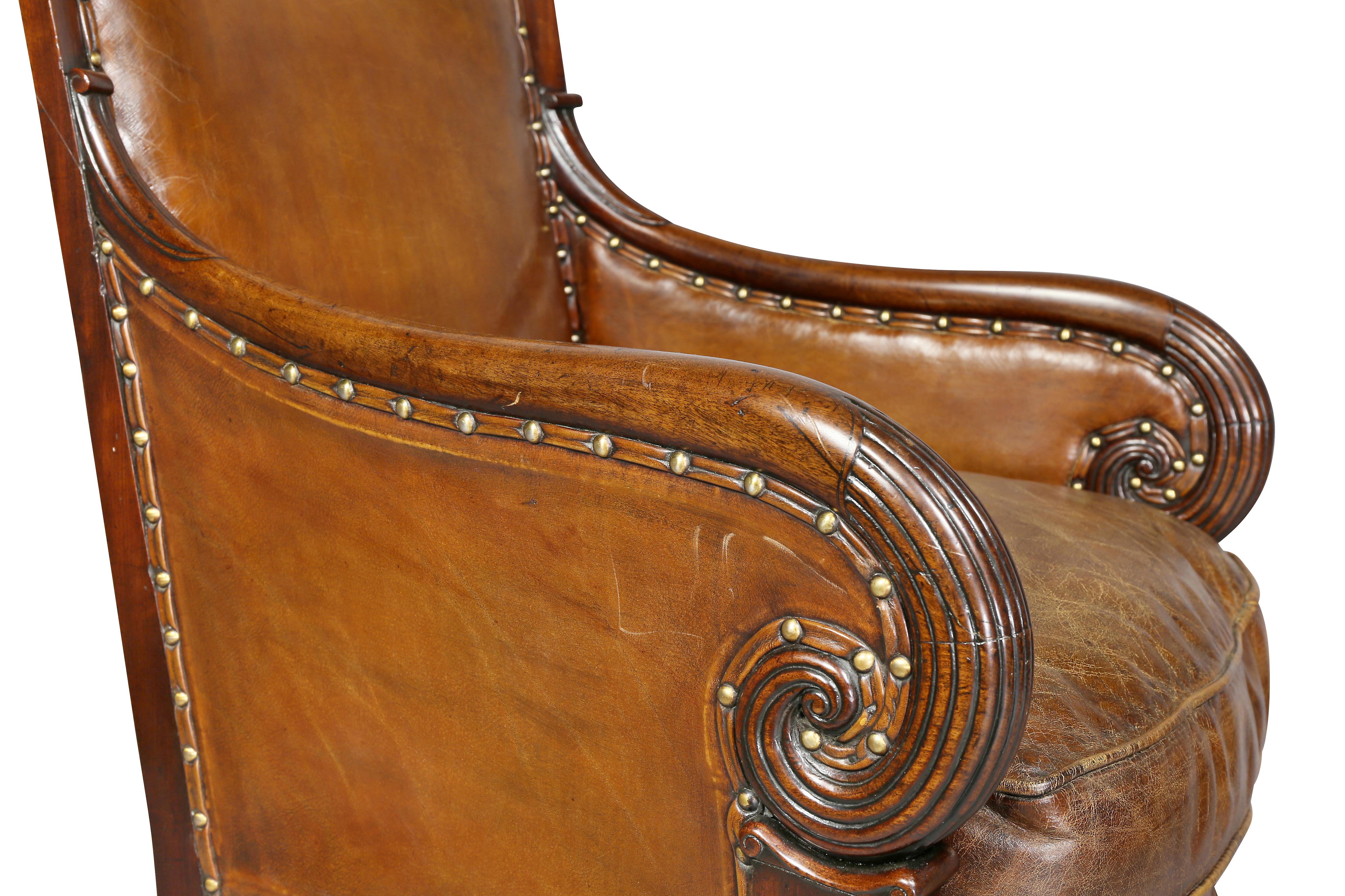 In the French Empire style with carved arched back downswept arms raised on saber legs.