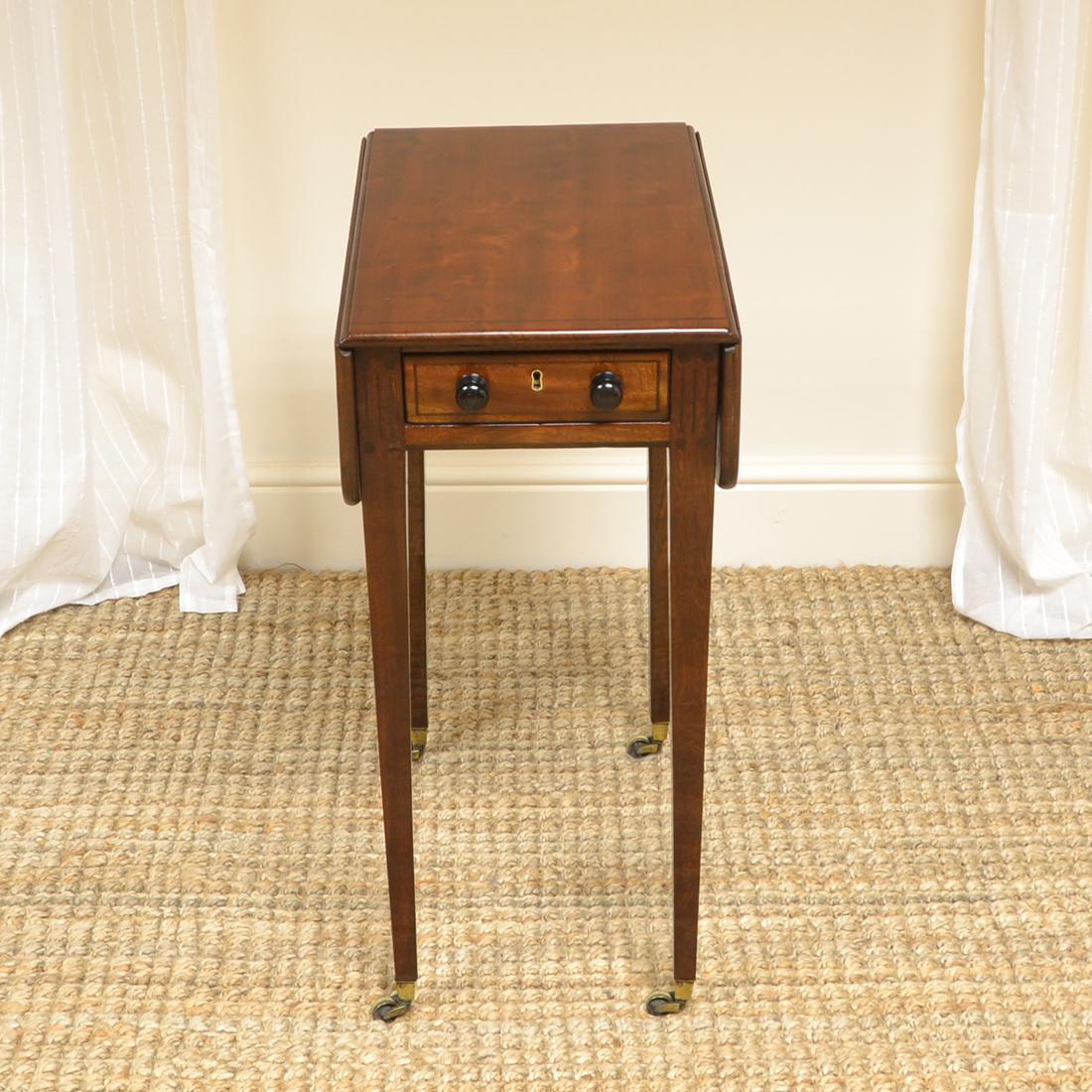 Unique small Regency mahogany antique baby Pembroke table.

Dating from circa 1830 this unique small Regency mahogany antique baby Pembroke table has a beautifully figured top with drop leaves and ebony string inlay. This sits above a working