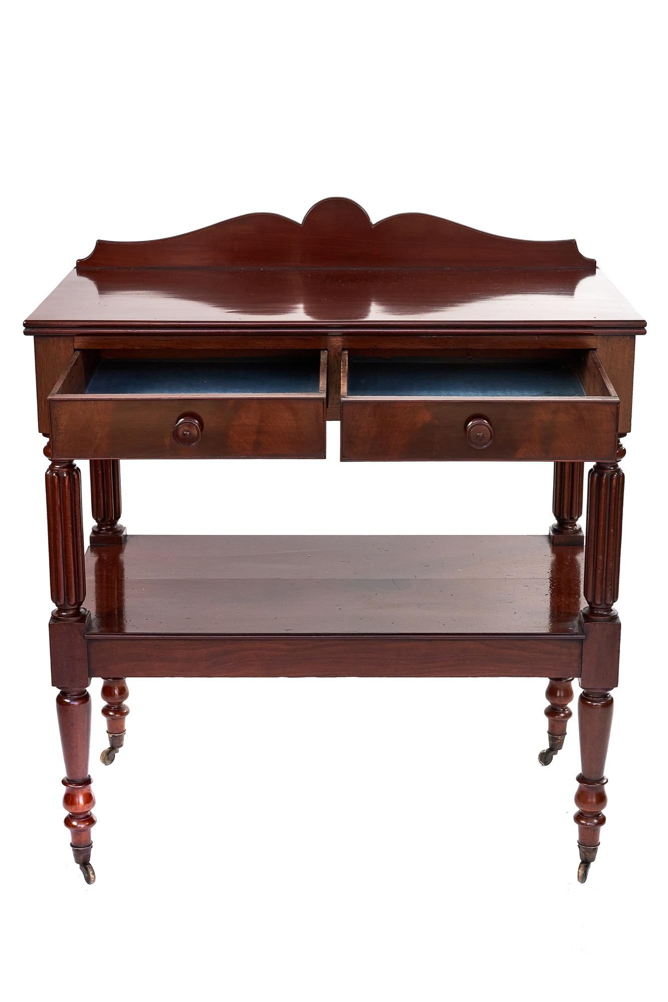 Regency mahogany antique two-drawer serving table having a quality mahogany top with reeded edge. It boasts an attractive shaped upstand, two drawers with turned mahogany knobs which open to reveal the original blue lined paper. The four supports
