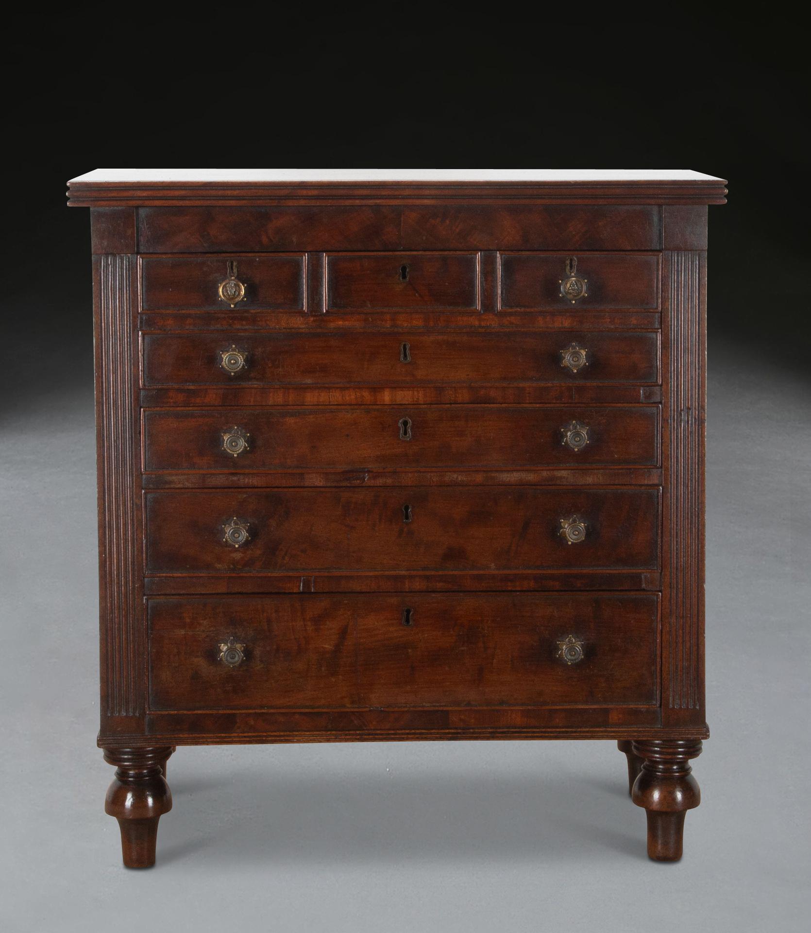 Petit coffre d'apprenti ou de collectionneur en acajou de style Régence.
Le tiroir supérieur est composé de quatre tiroirs plus petits, avec d'autres tiroirs en dessous et des boutons en laiton.
La partie supérieure présente un bord cannelé et des