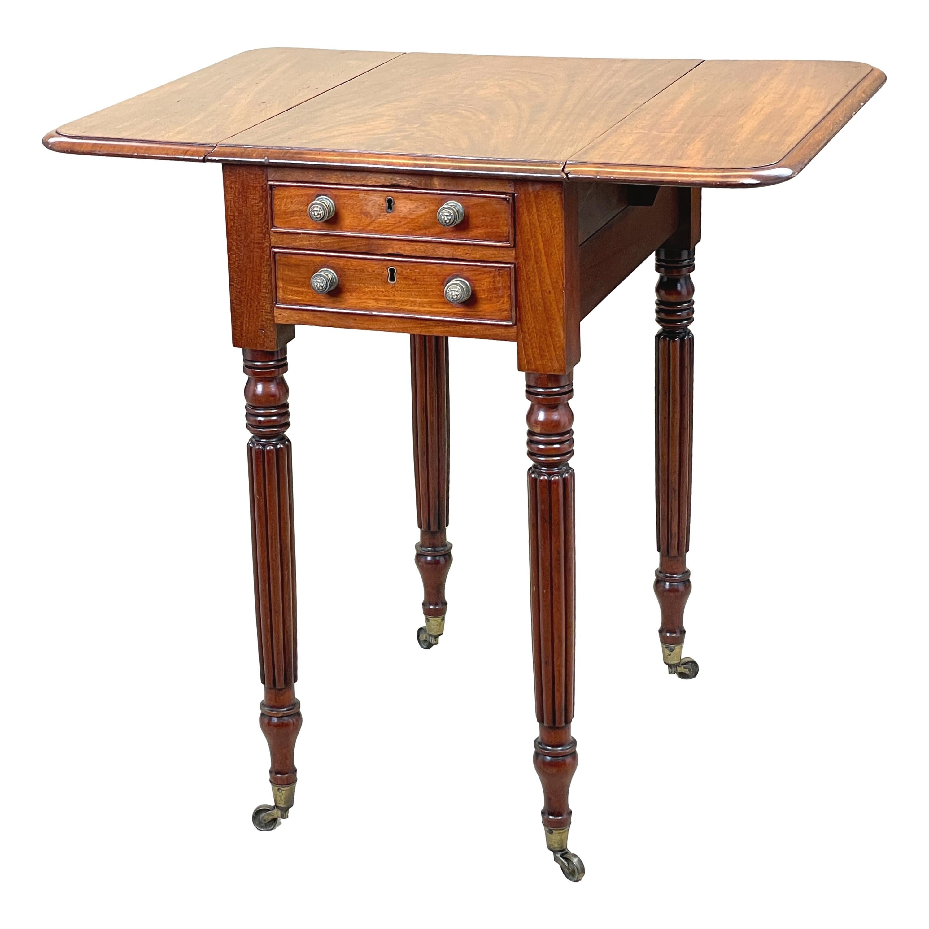 A very good quality regency period mahogany baby Pembroke table having
well figured top with flap to either side and two frieze drawers opposed by
two false drawers to reverse raised on elegant turned and reeded legs
with original brass