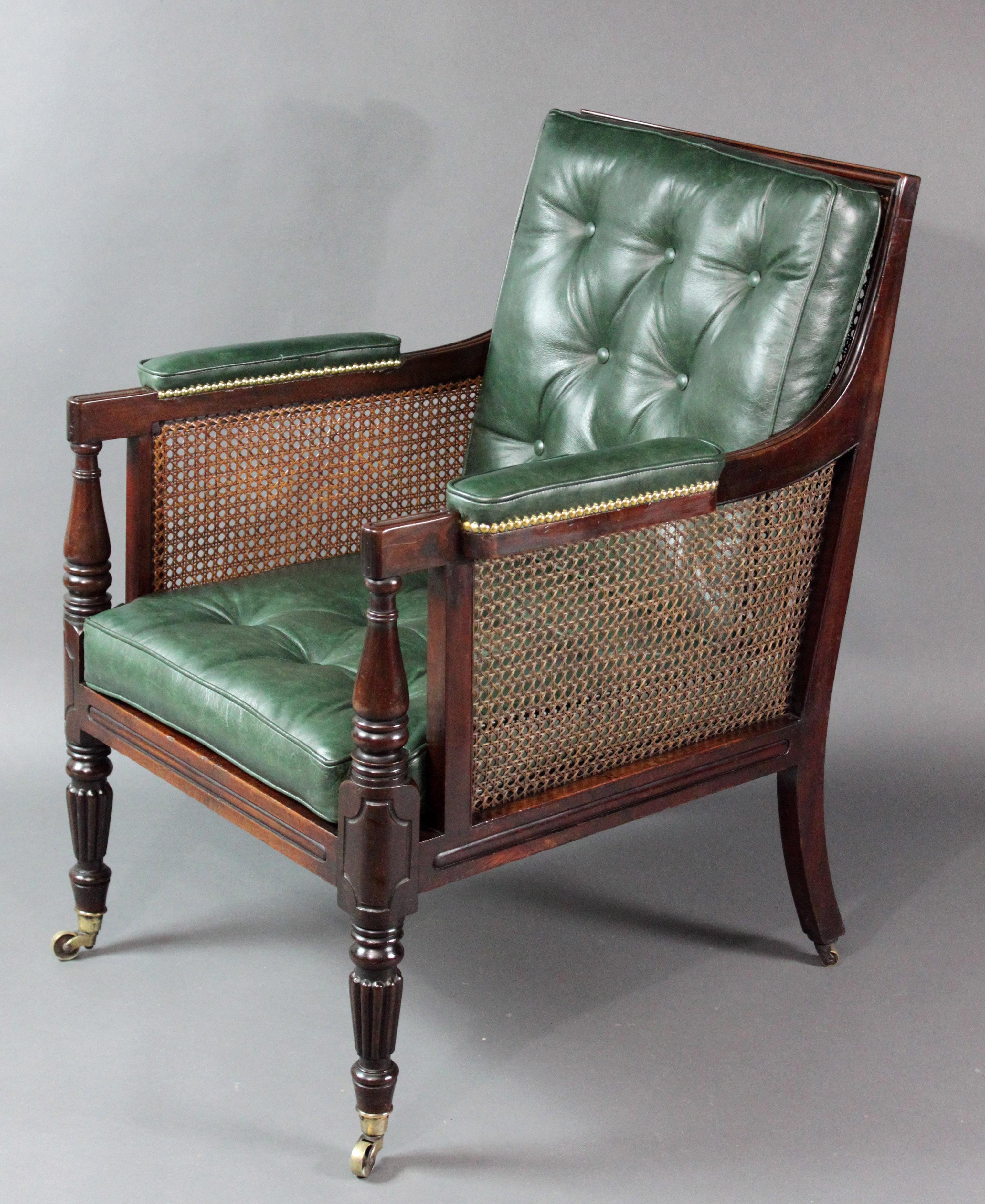 Regency mahogany bergère chair of a good large size; original color and patina, carved reeding on the legs, seat rail, arm rests and the framing around the back, original caning on the sides and the back, the seat is webbed and has never been caned;