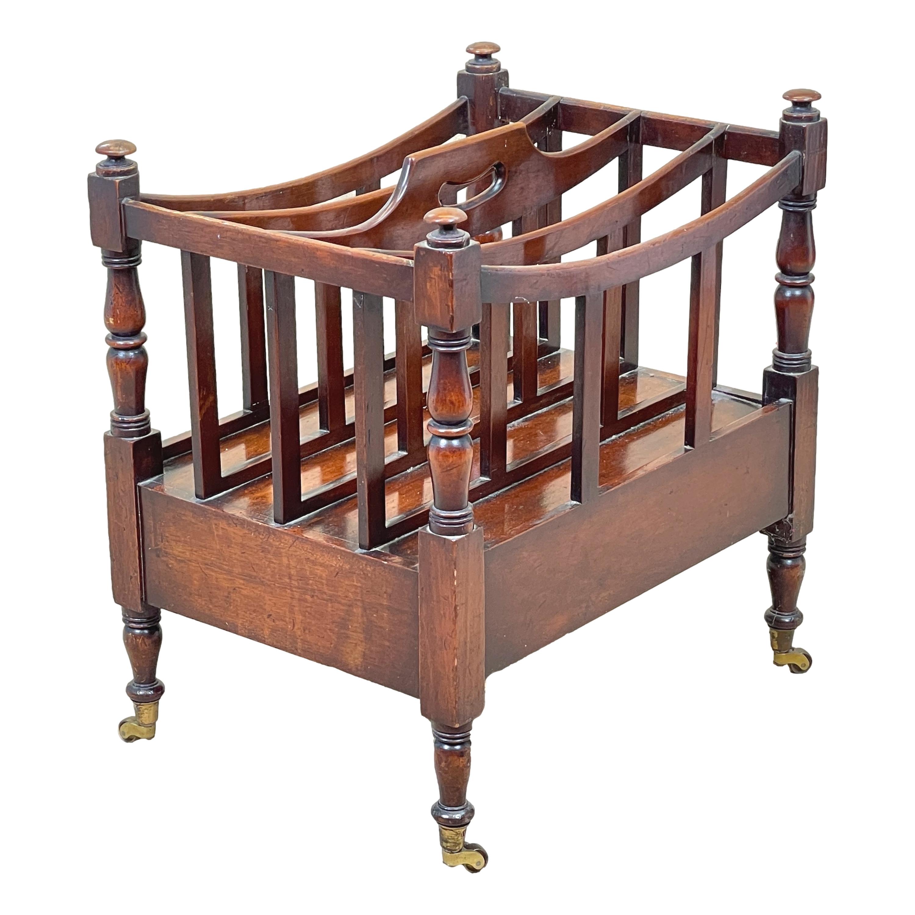 A very good quality early 19th century Regency period mahogany boat shaped canterbury with pierced carrying handle over four divisions and elegant turned upright supports, having one drawer to frieze with replacement brass knob, raised on elegant
