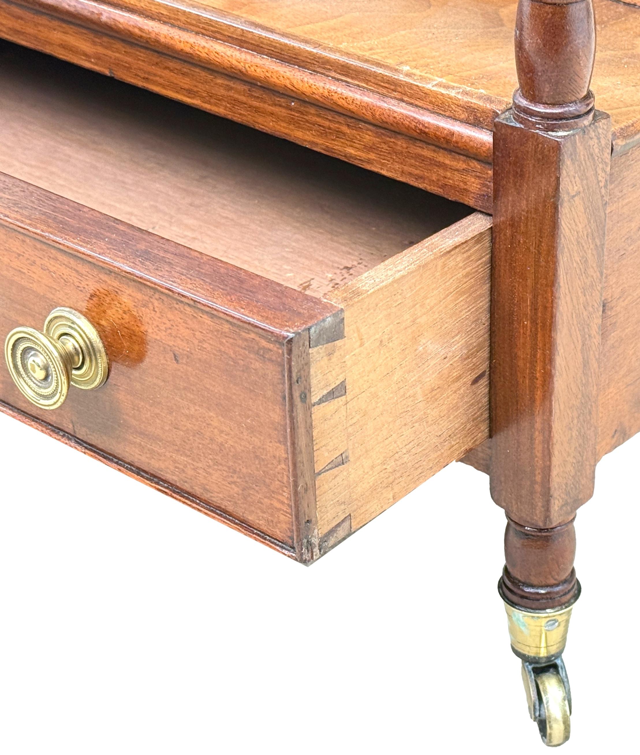 A Very Good Quality 19th Century Regency Period Mahogany Boat Shaped Canterbury Having Elegant Turned Upright Supports To Each Corner And Unusual Horizontal Slatted Divisions, Over One Frieze Drawer With Later Brass Handles, Raised On Turned Legs