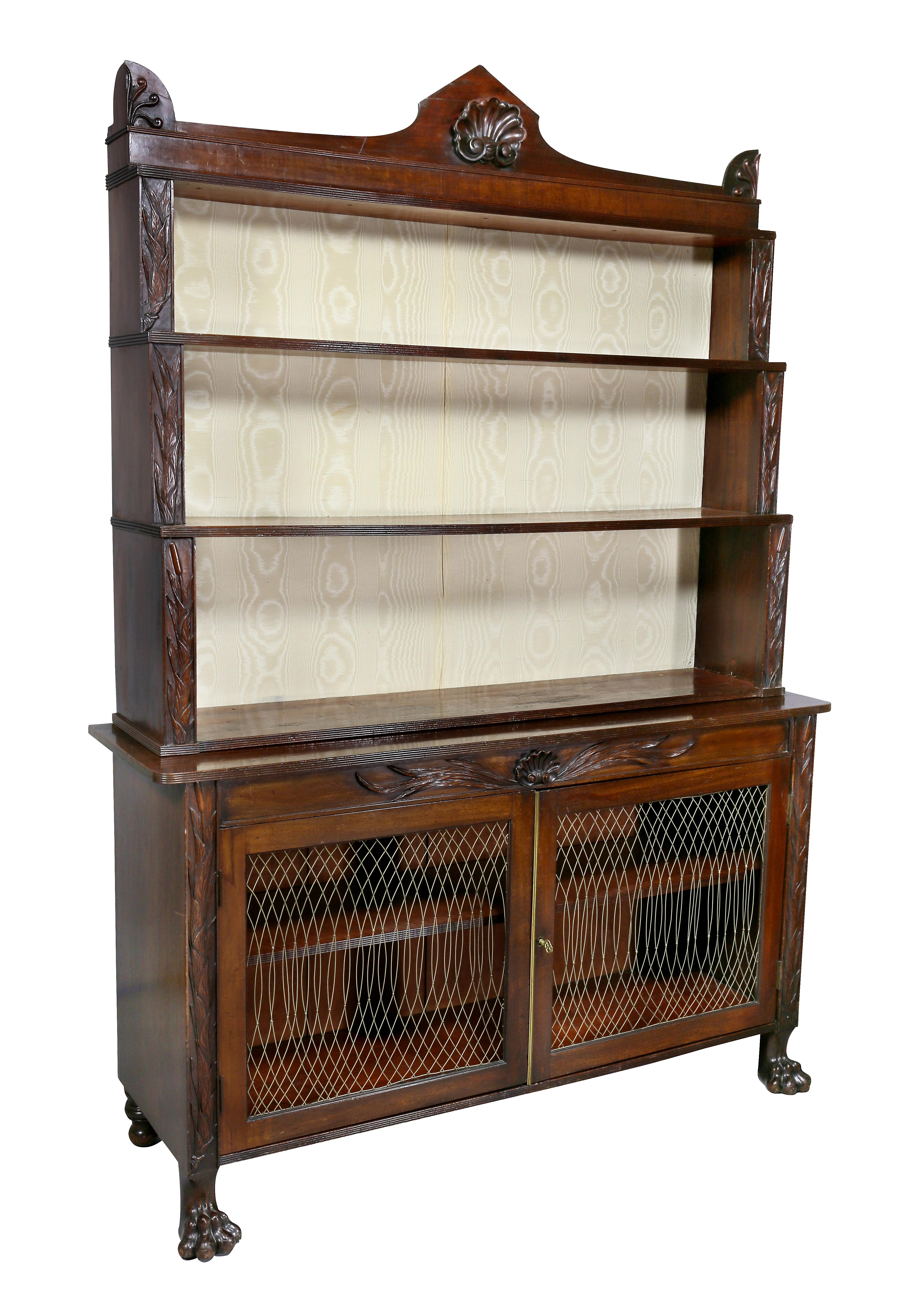With shelf superstructure with back panel with central shell carving flanked by anthemion over three shelves, all flanked by carved uprights,
base with a pair of cabinet doors with grillwork and central carved shell, flanked again by carved