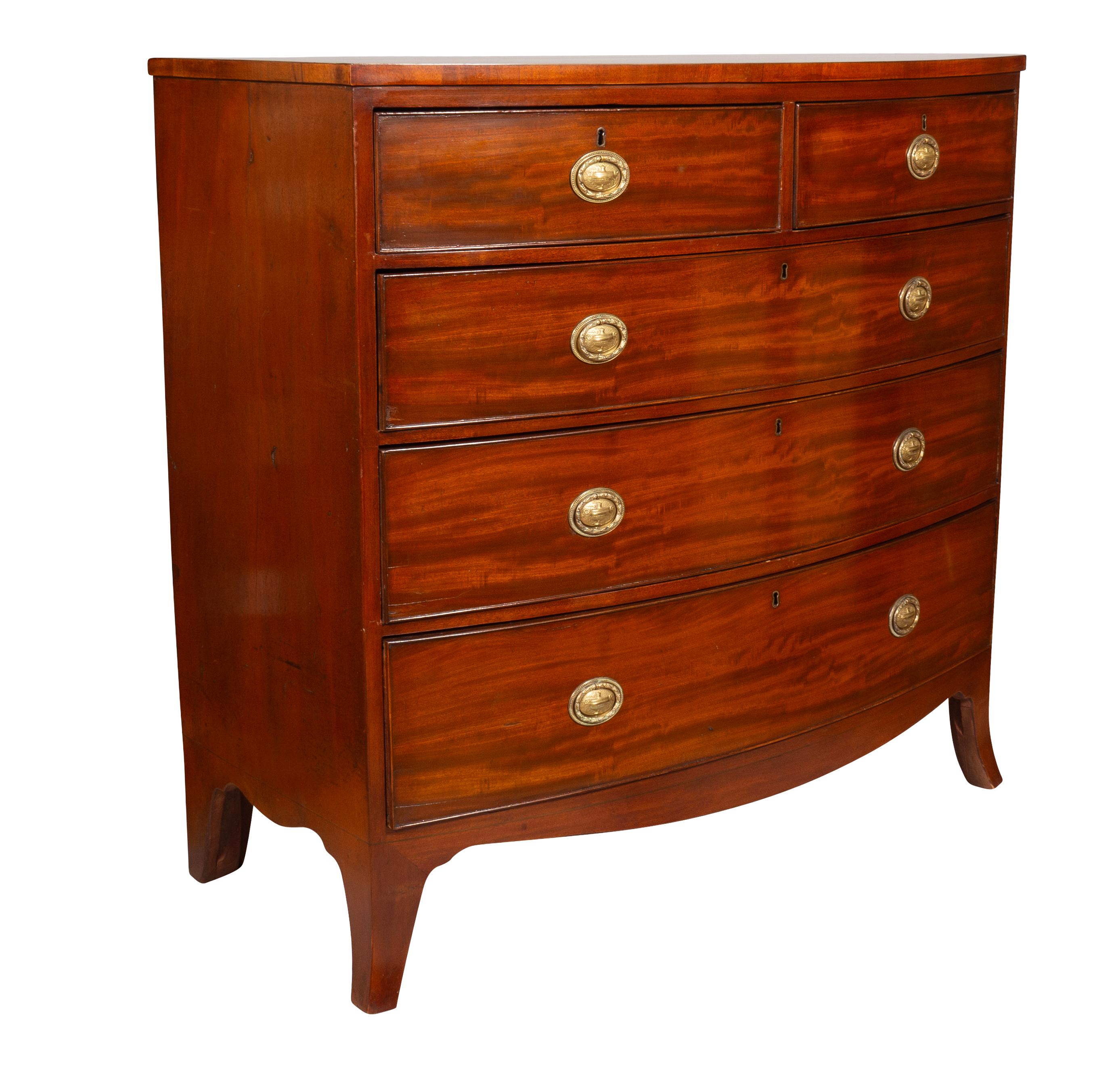 Rectangular bow front top with two over three drawers with oval brass handles. Splayed legs.