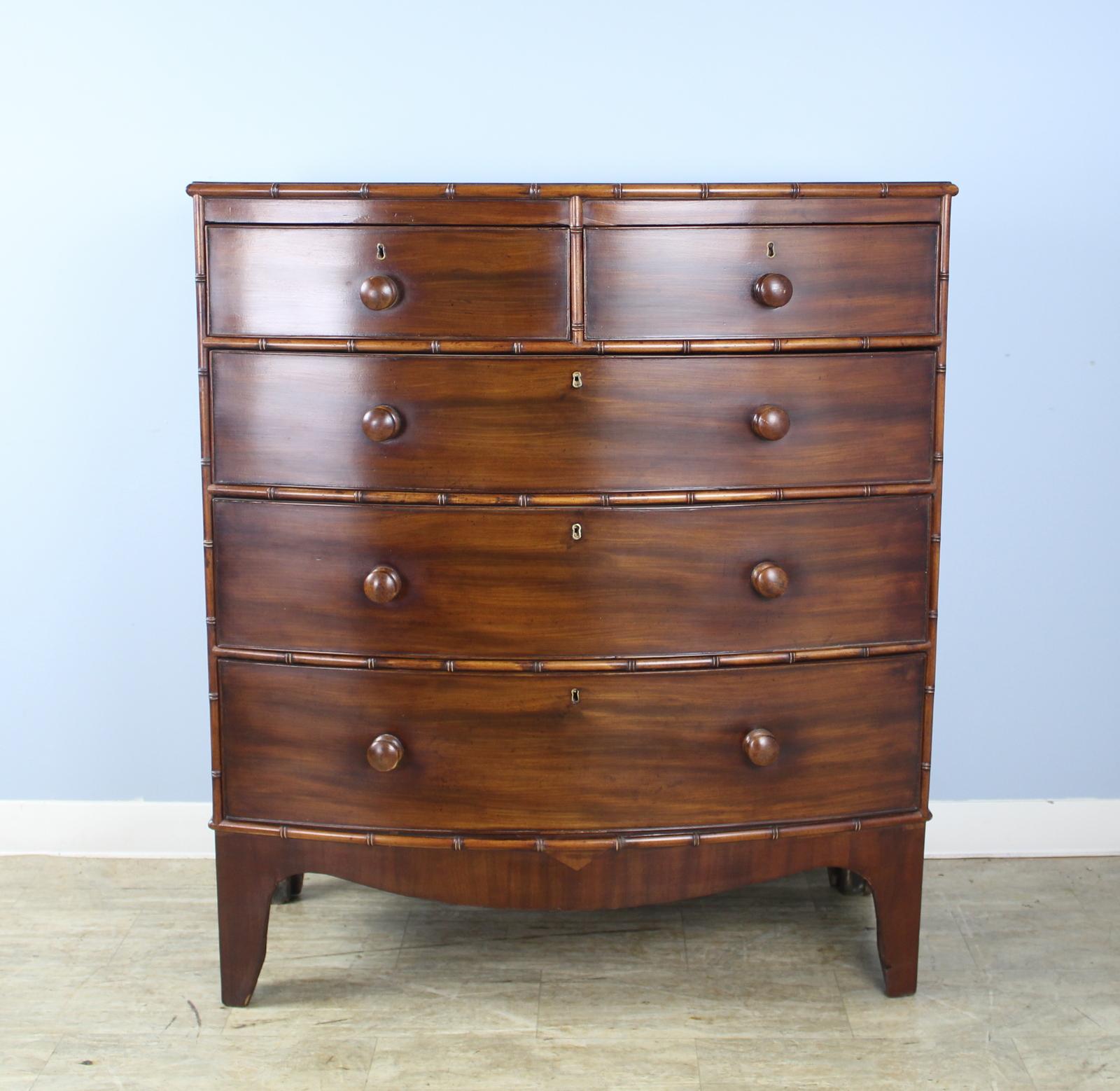 A stunning early English mahogany bowfront chest of drawers in very good condition with very good faux bamboo detail. Original bracket feet and nice grain give this piece eye catching appeal. Drawers open and close snugly and easily.