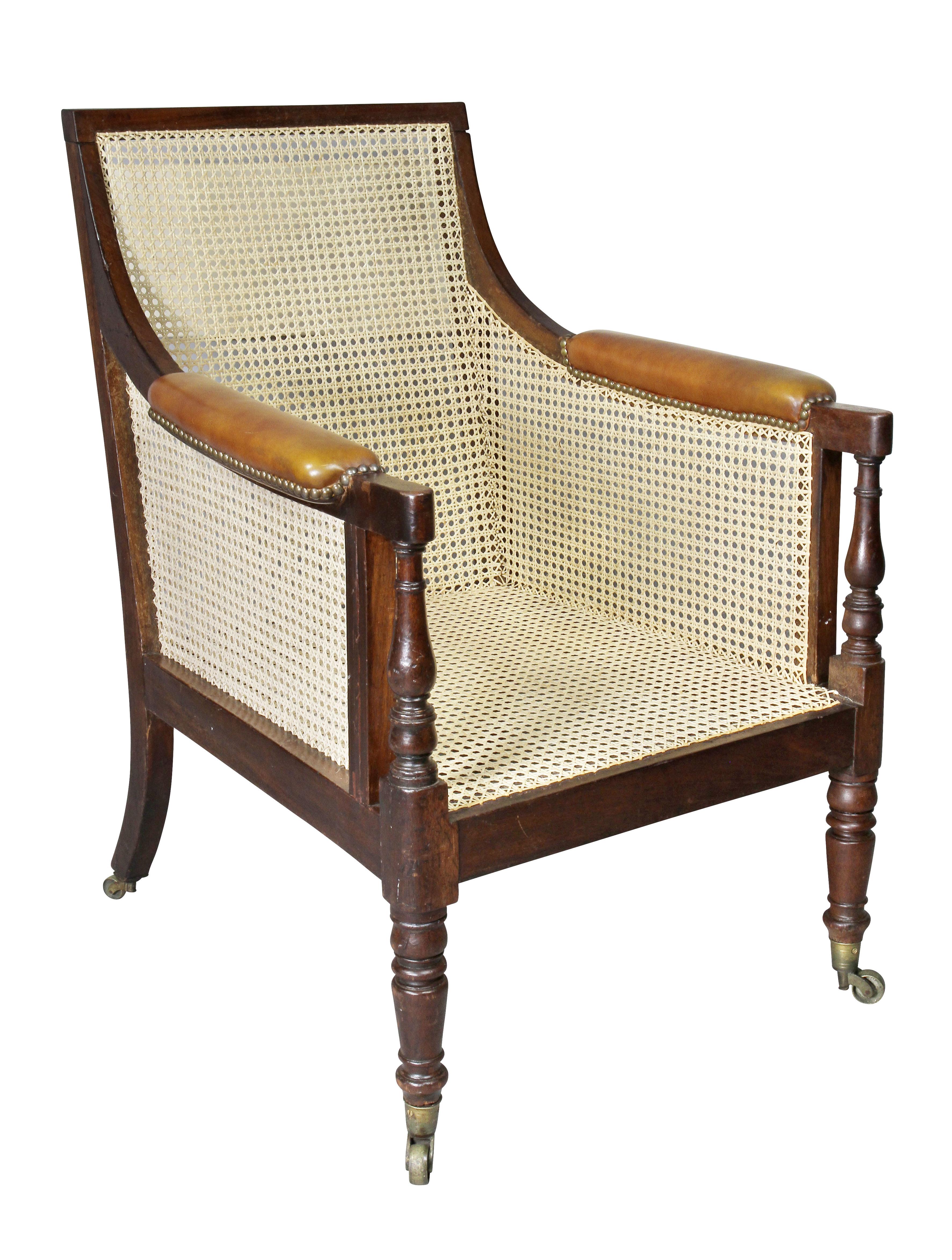 Rectangular back and seat, all newly hand caned, loose brown leather cushions, raised on circular tapered legs and casters.