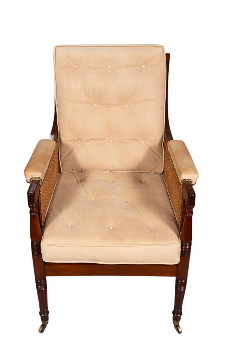 With straight back and arms and caned overall in excellent condition. Seat recently newly caned. Used suede cushions and raised on circular tapered legs with brass cup casters. Very comfortable.
