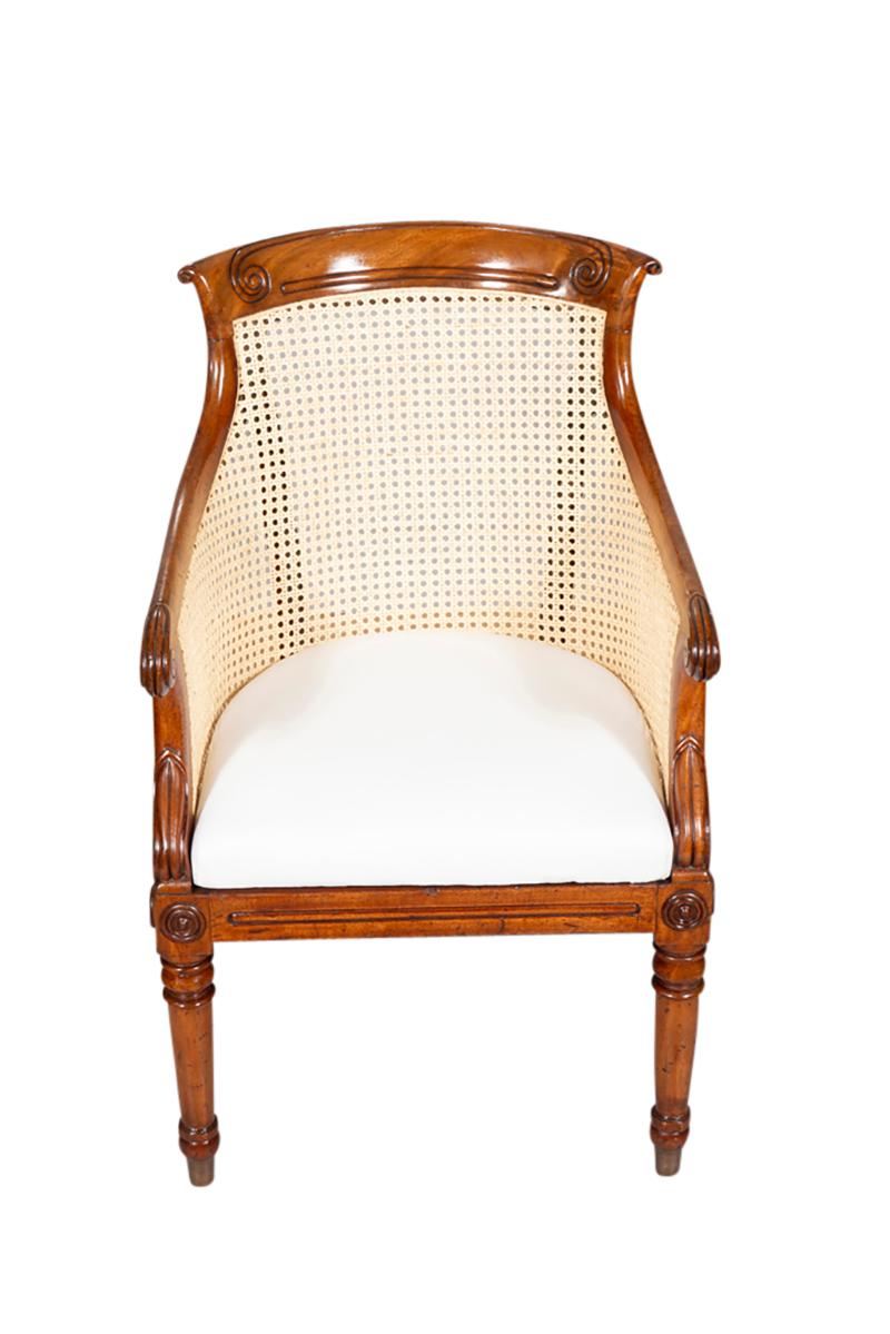 With a curved carved back and sides raised on circular tapered legs. Nice carved details overall. Completely newly caned with removable upholstered original seat newly upholstered in muslin.