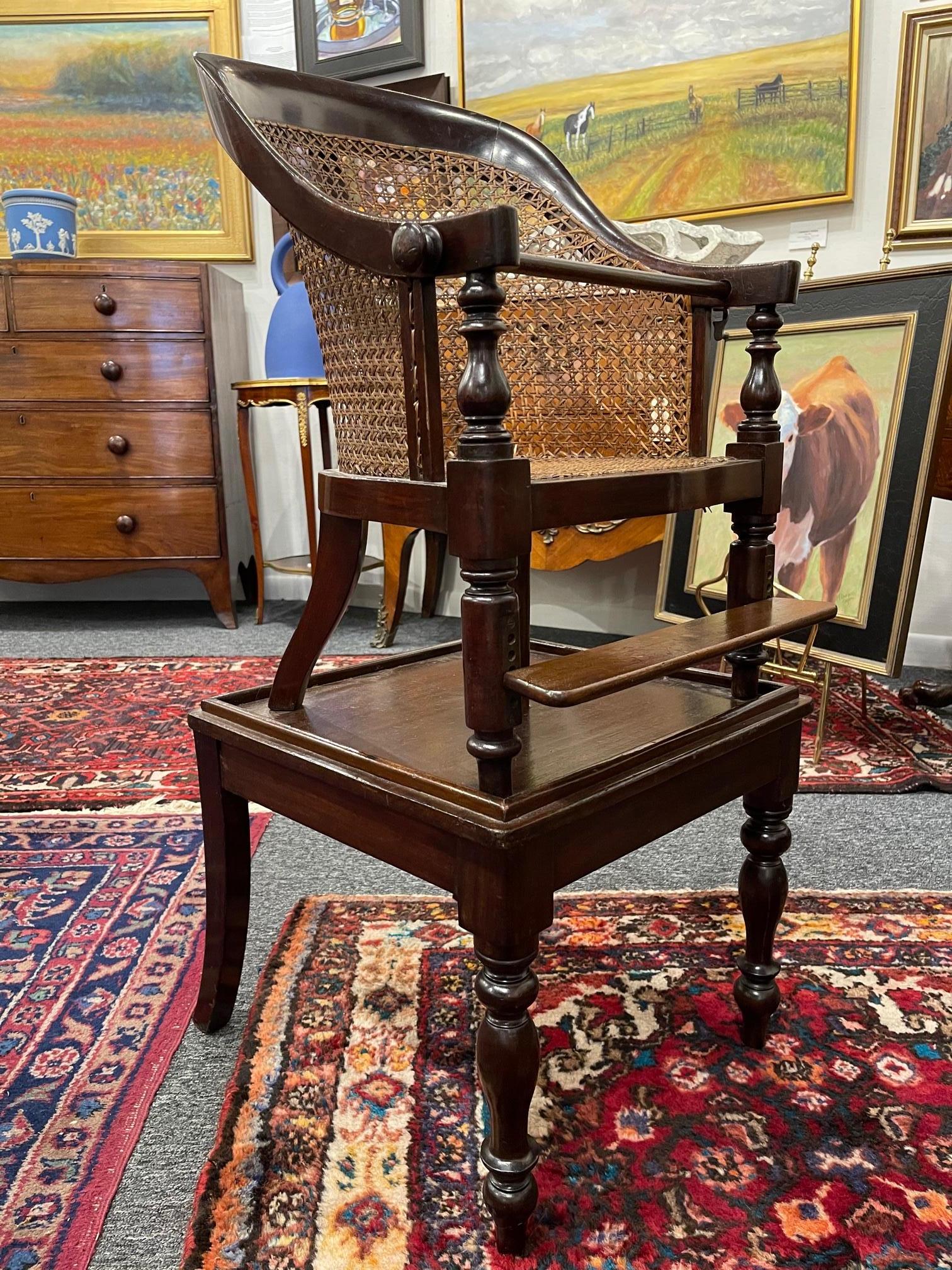 Regency mahogany child's chair with an adjustable foot rail and safety bar, raised on a table that can be detached, circa 1830.
 