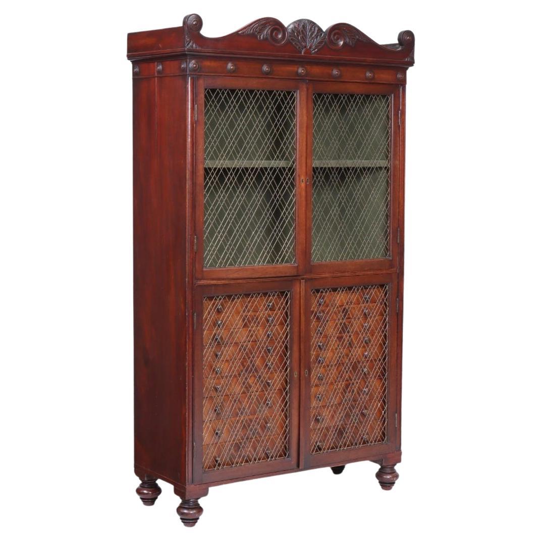 An English Regency mahogany collector's display cabinet is an elegant and refined piece of furniture typical of the Regency period (early 19th century, roughly 1811–1820). The style is known for its classical influences, clean lines, and graceful