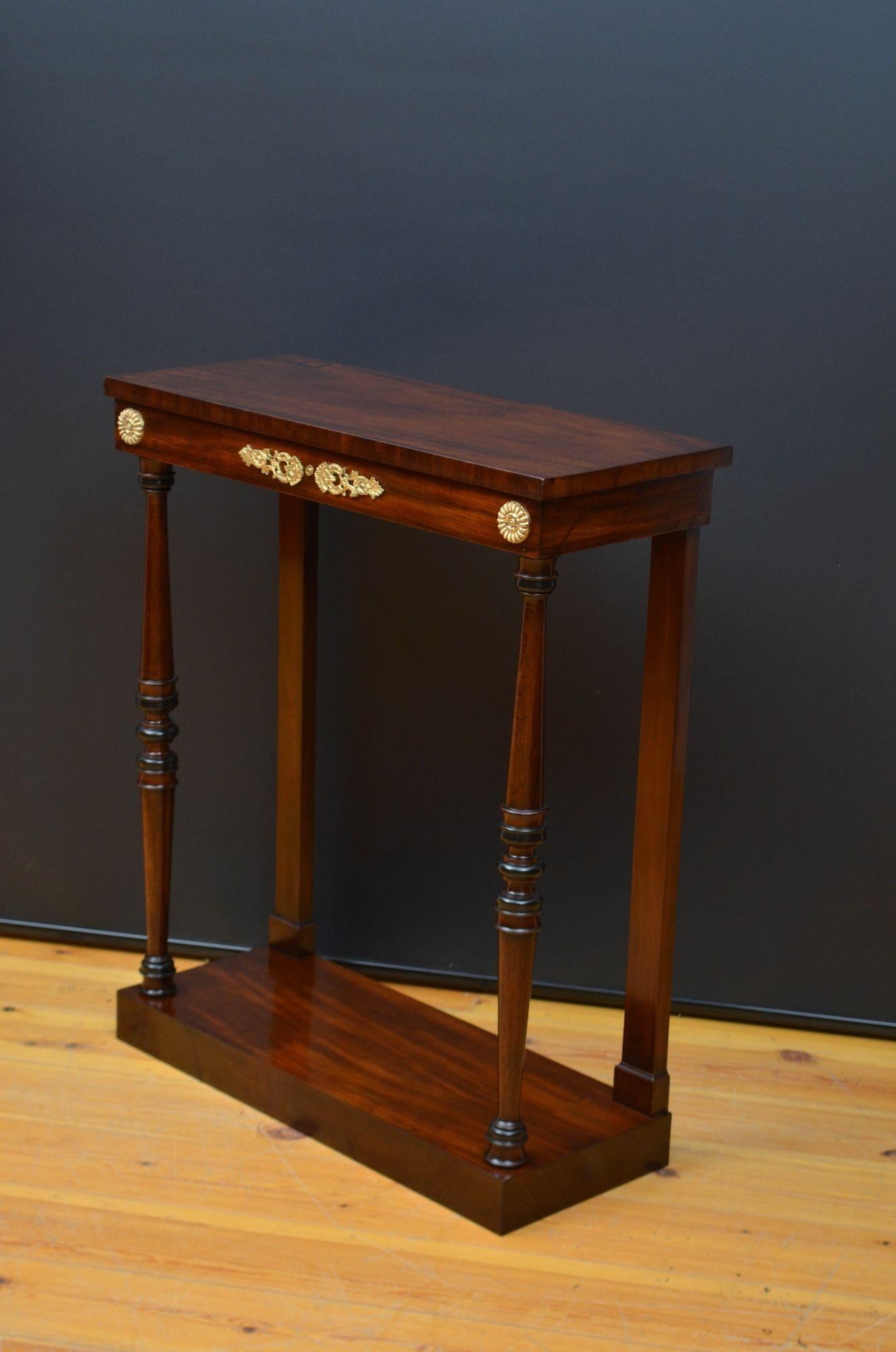 Sn5569 Very stylish tall and narrow Regency / George IV console table in mahogany, having figured mahogany top above a shallow frieze with decorative ormolu, raised on turned and ringed legs terminating in figured mahogany platform base. This