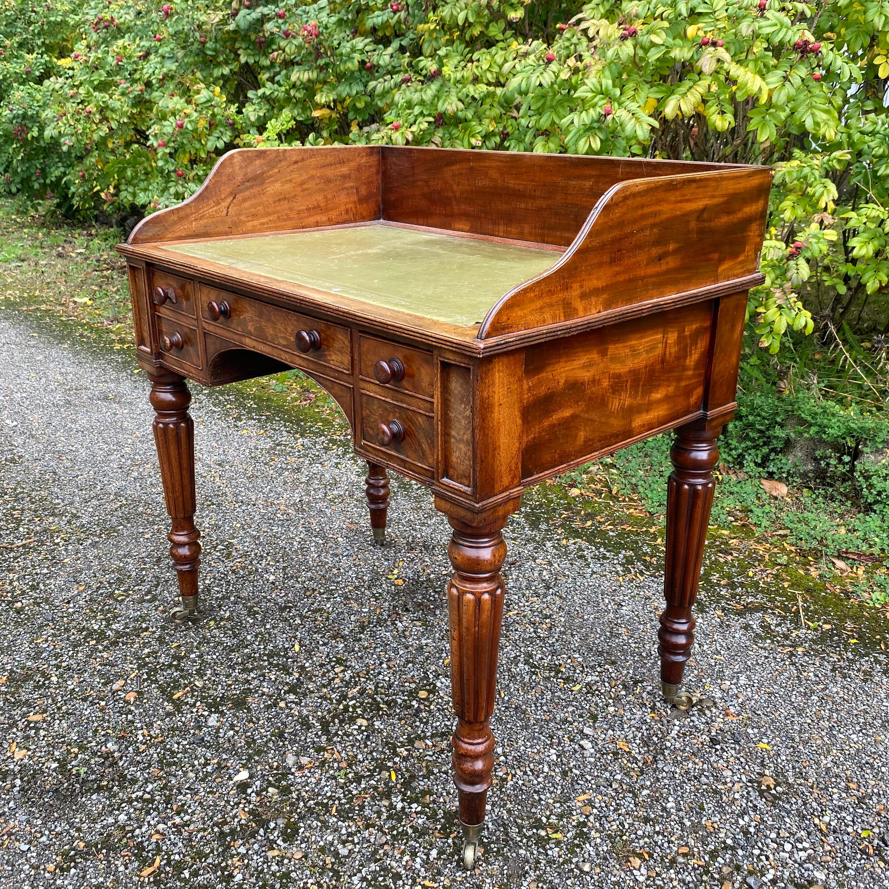 Scrittoio in mogano dell'inizio del XIX secolo di ottima qualità, realizzato secondo lo stile di Gillows of Lancaster & London.  Il piano di scrittura è incastonato con una superficie in cuoio verde e circondato da una galleria a tre quarti sopra un