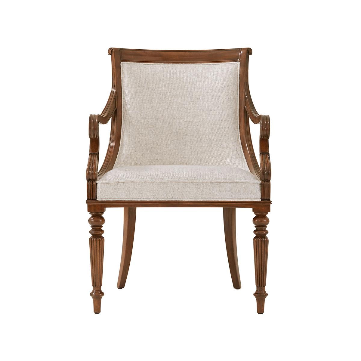 Carved mahogany scoop back dining armchairs with a paneled and upholstered backrest, beautifully carved scroll arms on turned and reeded legs.

Dimensions: 24.5