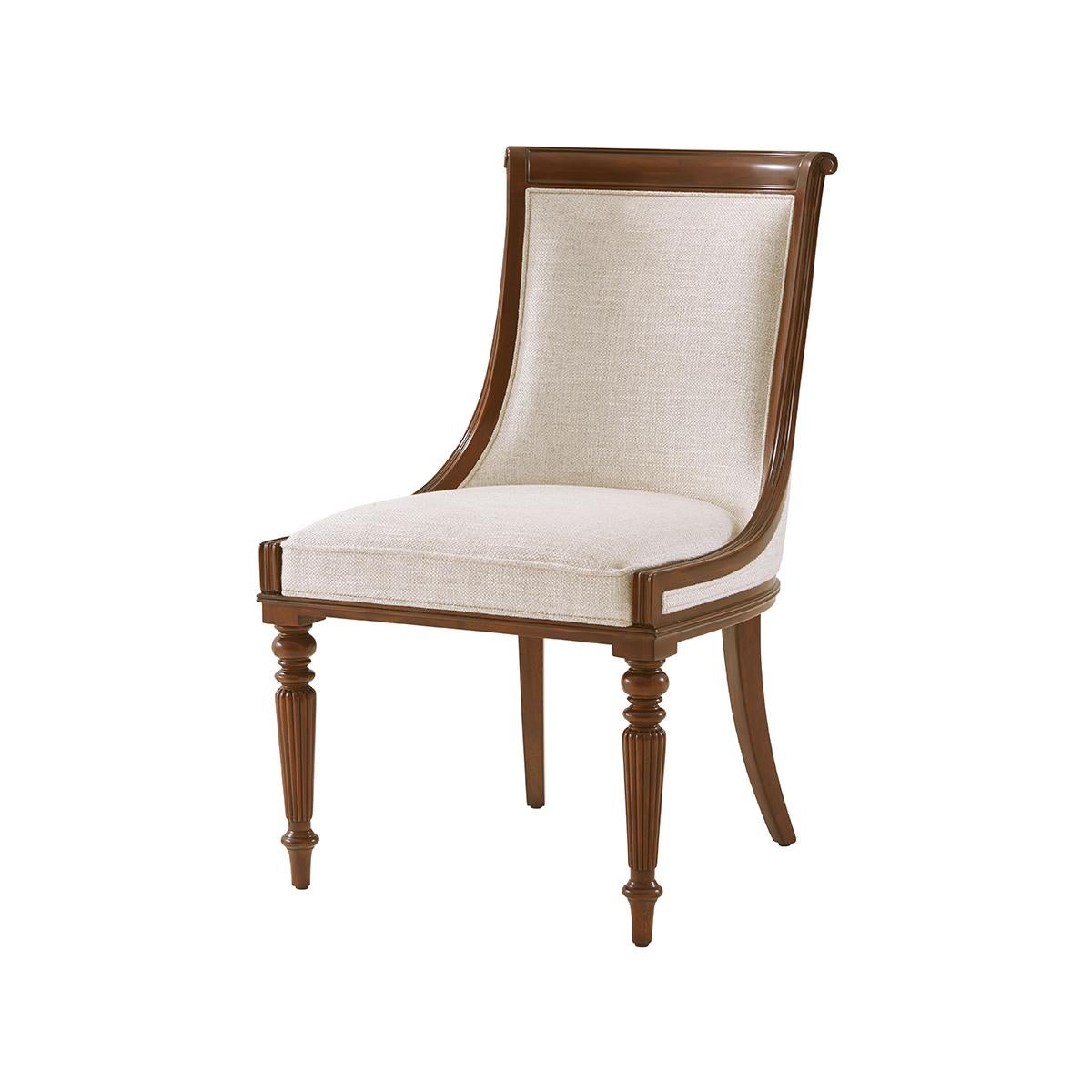 Carved mahogany scoop back dining chairs with a paneled and upholstered backrest, beautifully carved frame on turned and reeded legs.

Dimensions: 22.5
