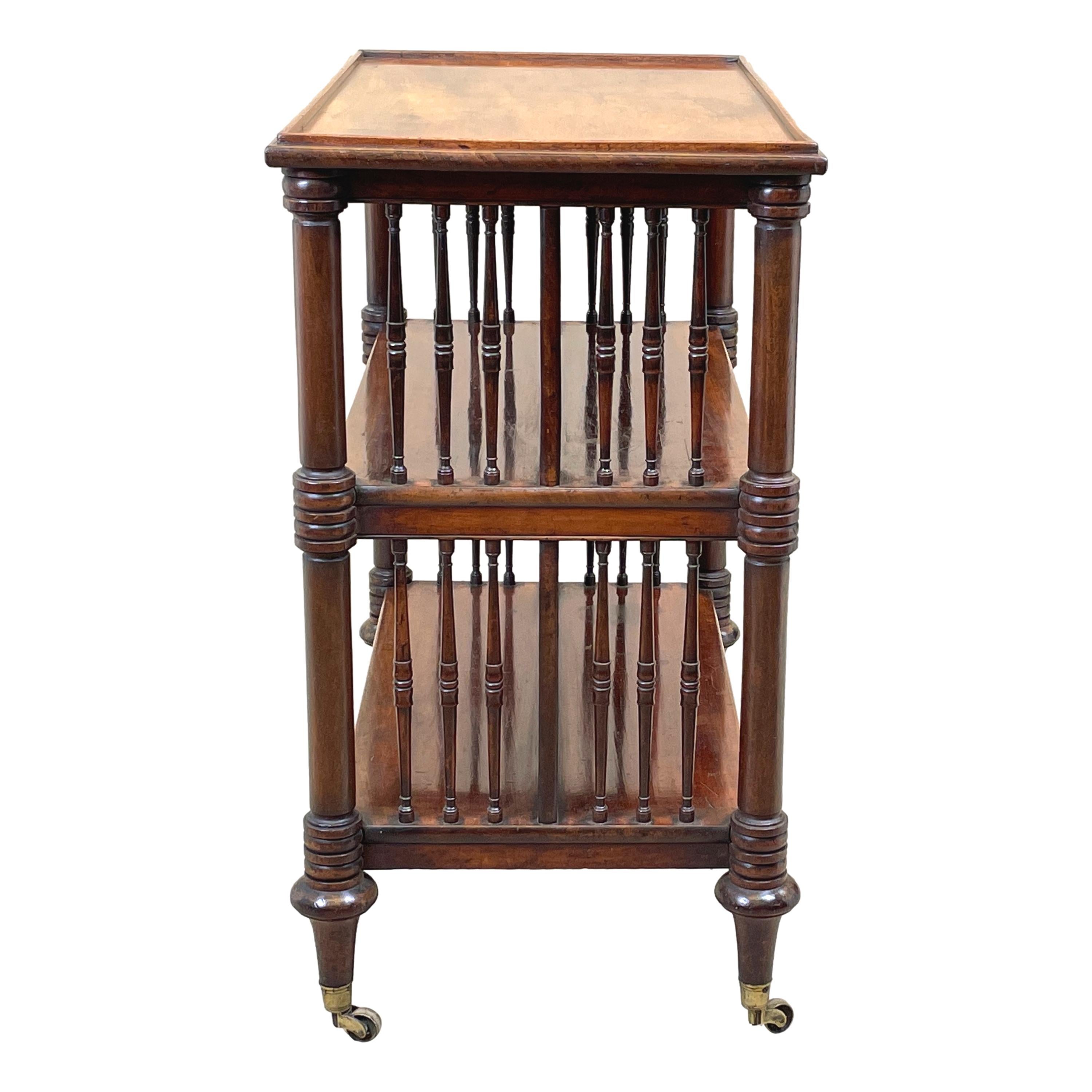 A very fine quality late regency period mahogany double sided open bookcase, or trolley, having well figured rectangular top with gallery mould, over two well figured further tiers with central divider and elegant spindle turned upright supports to