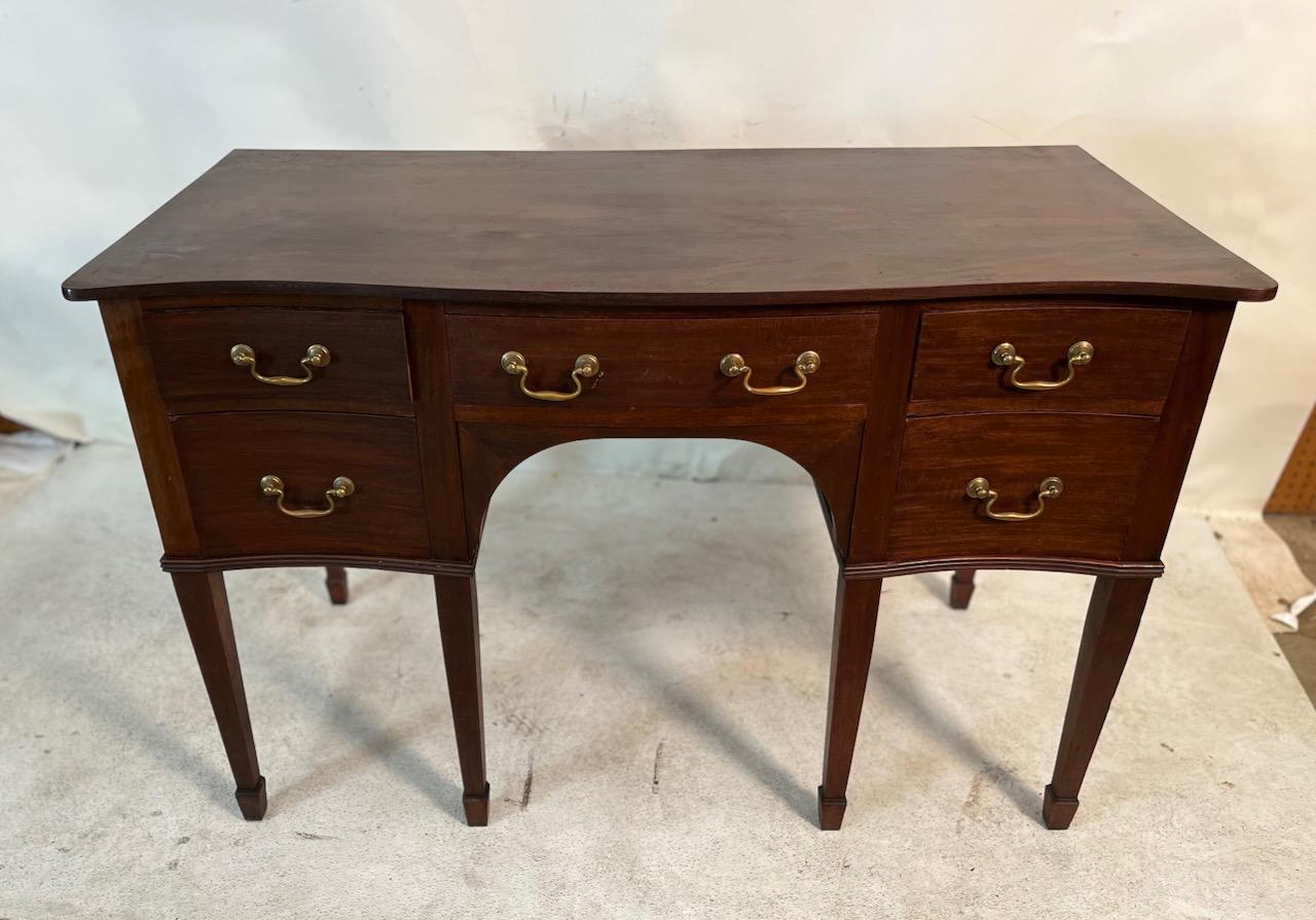 Simple coiffeuse Regency en acajou avec 5 tiroirs : un au centre et deux à droite et à gauche.  Cuivres originaux.