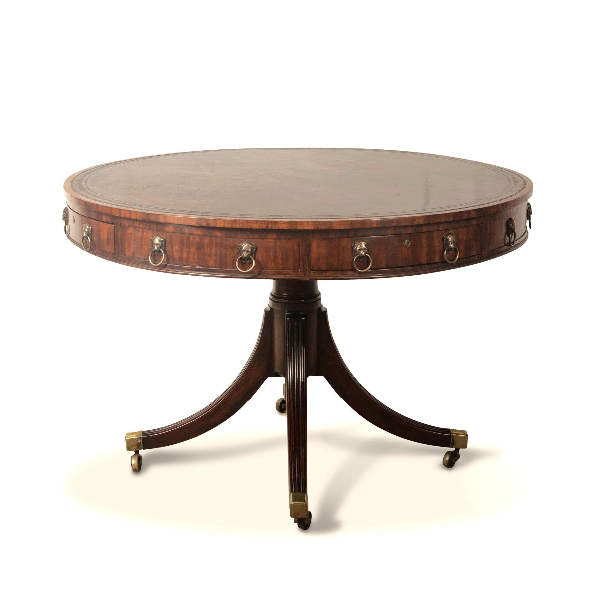 A good Regency mahogany drum table, the revolving top and crossbanded edge with tooled leather inset and above an arrangement of 4 drawers and 4 dummy drawers with original brass leopard head handles and moulded frieze. All raised on on a turned