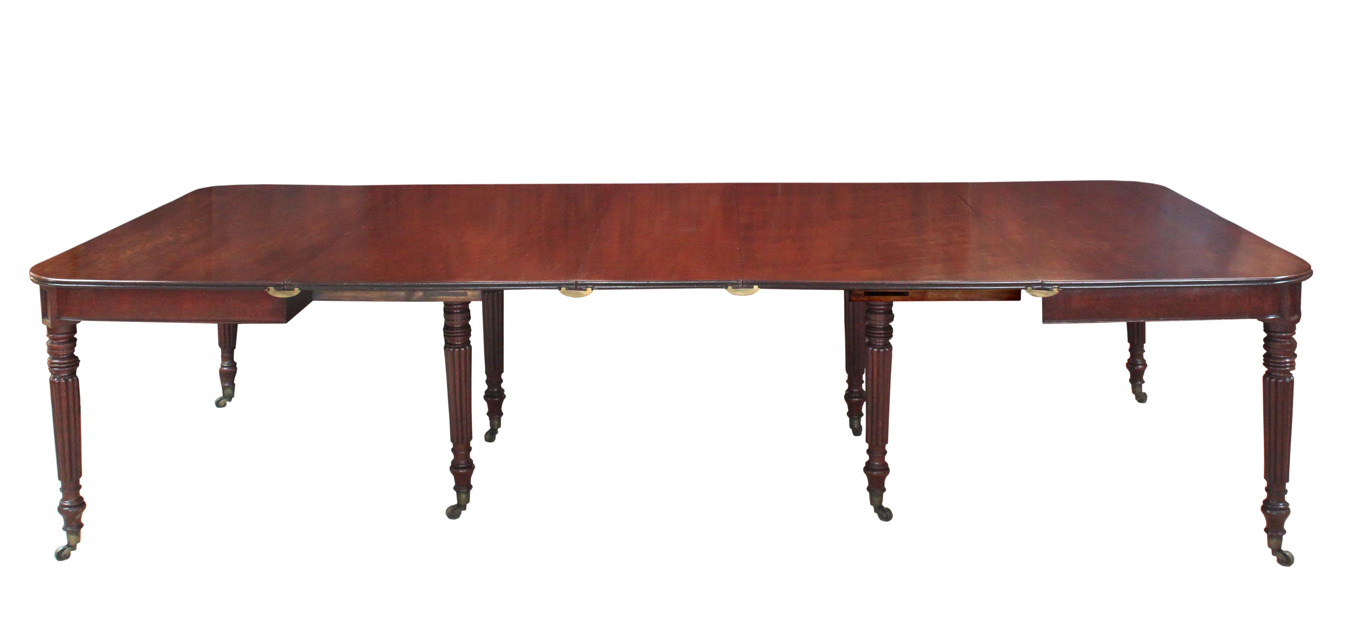 A fine Regency mahogany dining table attributed to Gillows of Lancaster: good model with shallow frieze, rectangular tablets at the top of the legs, elegant slim turned and reeded legs with brass castors and oak extending action with compartment to