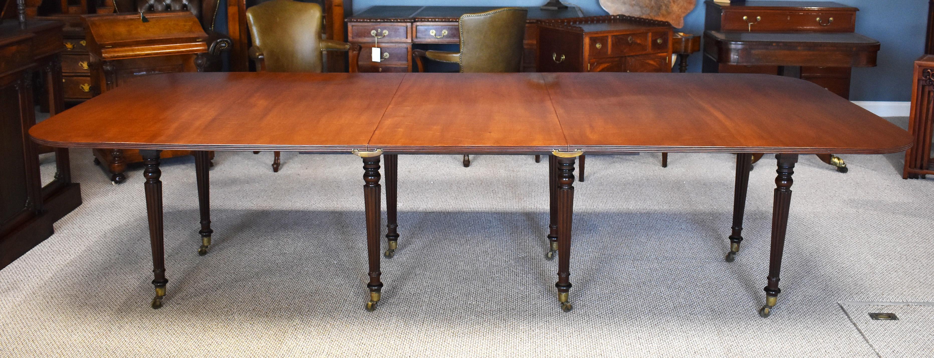 Regency mahogany dining table in good condition, stands on eight elegant reeded legs all fitted with brass castors. The centre turns on its base and the two large leaves are held in place by brass clips. When the leaves are not added the table has