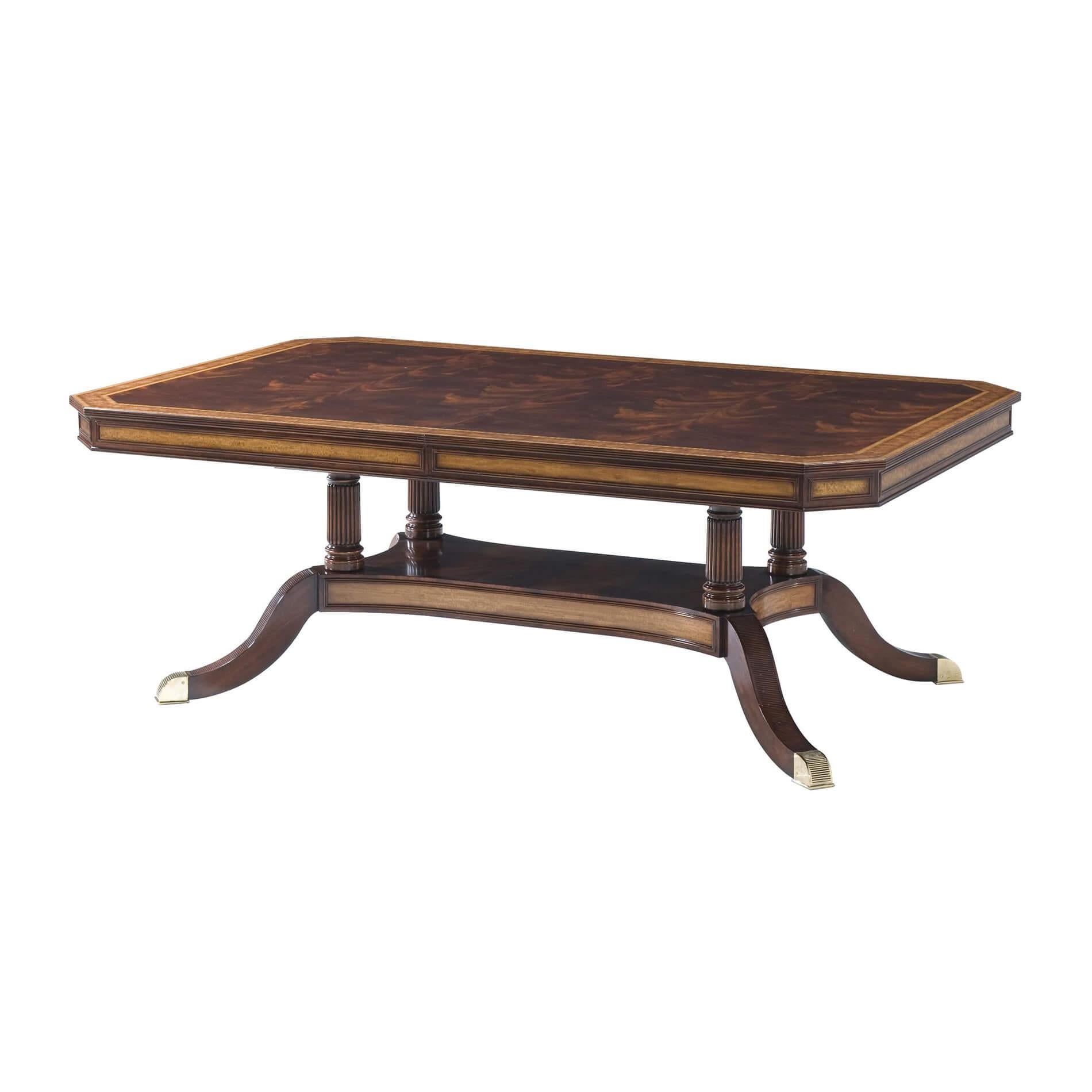 A mahogany, figured mahogany veneered and crossbanded extending dining table, the rectangular top opening to accommodate two additional self-storing leaves, the paneled satinwood veneered frieze above a bold base of four turned reeded columns on a