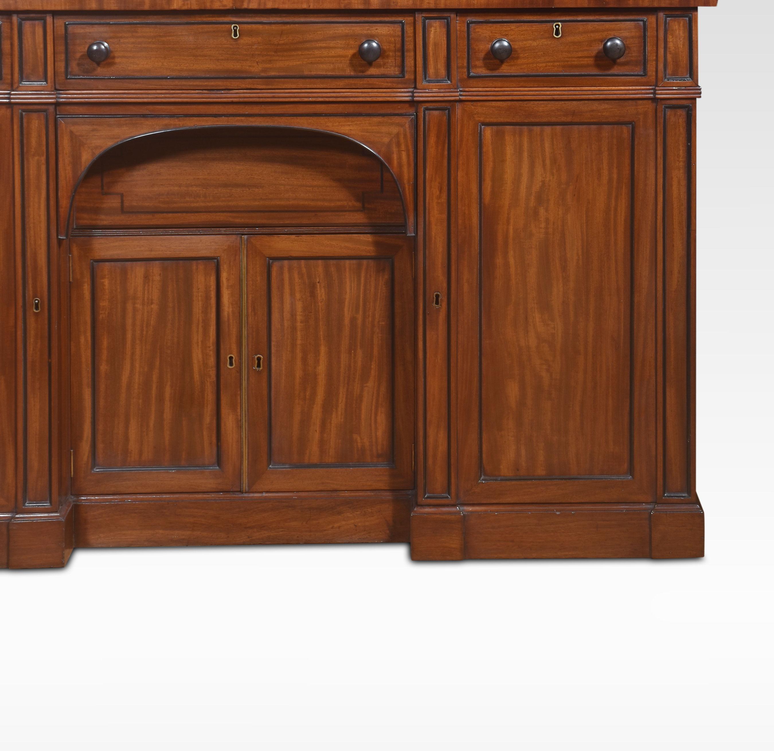 19th century Regency sideboard. The large rectangular well-figured top Above an arrangement of freeze drawers with ebonies mouldings. The base section is fitted with a central drawer having two cupboards below flanked by further panelled cupboard