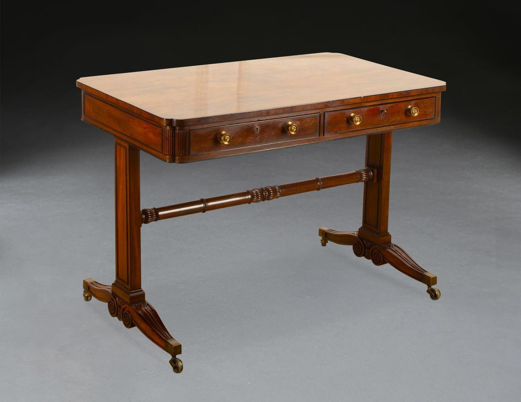 An elegant Regency library/centre table, of mahogany and ebony, the well figured top with re-entrant corners and ebony line inlay above a two drawer frieze with original brass knobs and ebony mouldings, with repeating re-entrant corners and reeded