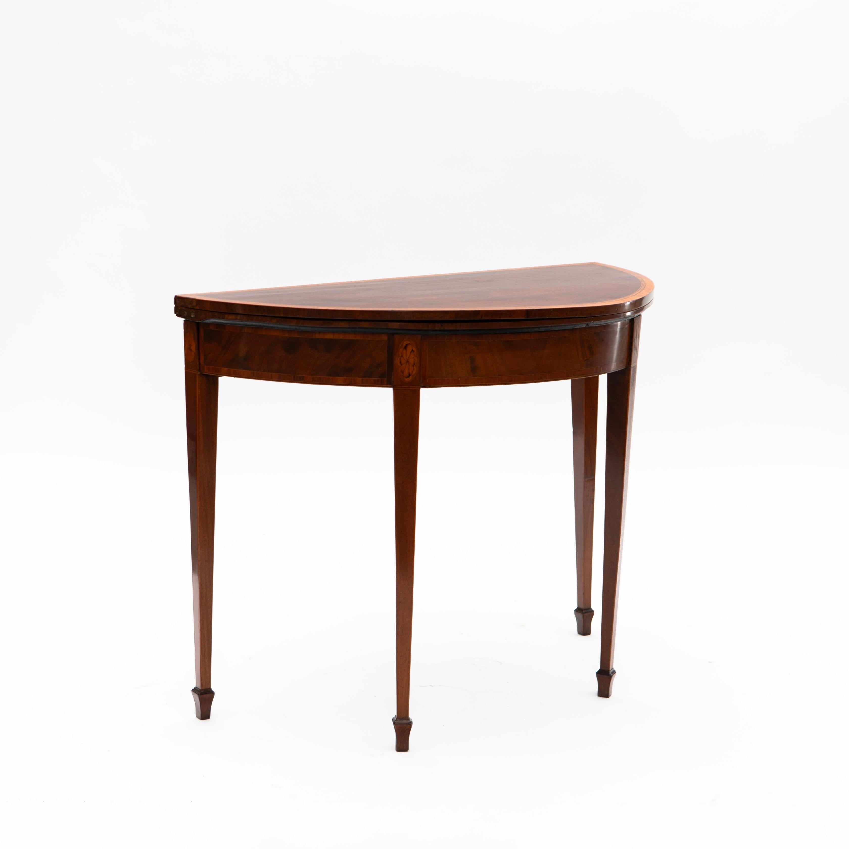 Elégante table à jeux de la période Regency en Angleterre, vers 1810-1815.

Fabriqué en acajou, le tablier est décoré de fines incrustations en bois de satin et en érable, tandis que les pieds fuselés sont ornés d'incrustations ovales en bois de