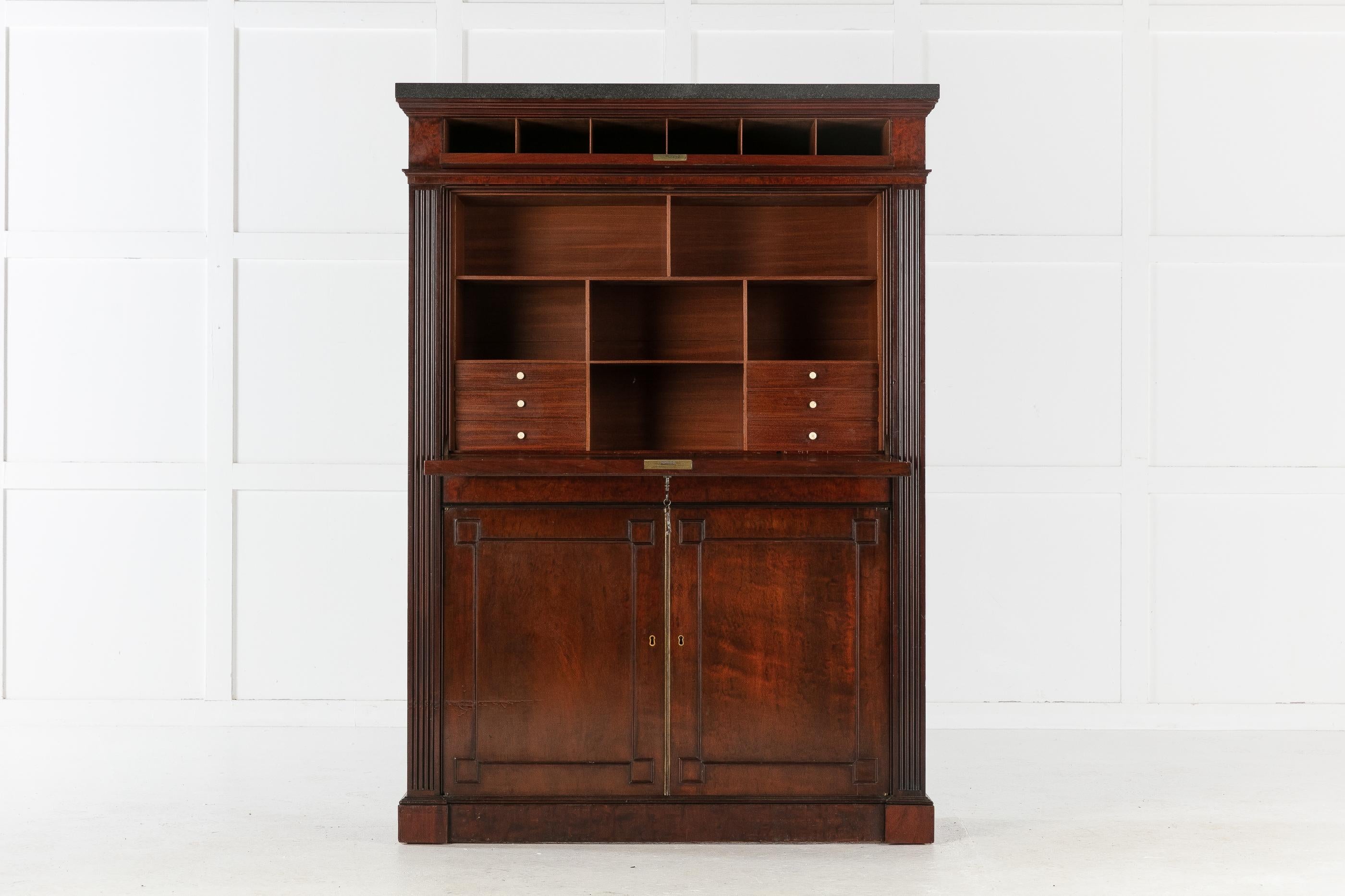 Regency fiddleback mahogany secretaire à abattant in the manor of Gillows, with a black slate top. A cantilevered fall front, having typical Gillow mouldings, opens to reveal several drawers and pigeon holes, and an original blue leather writing