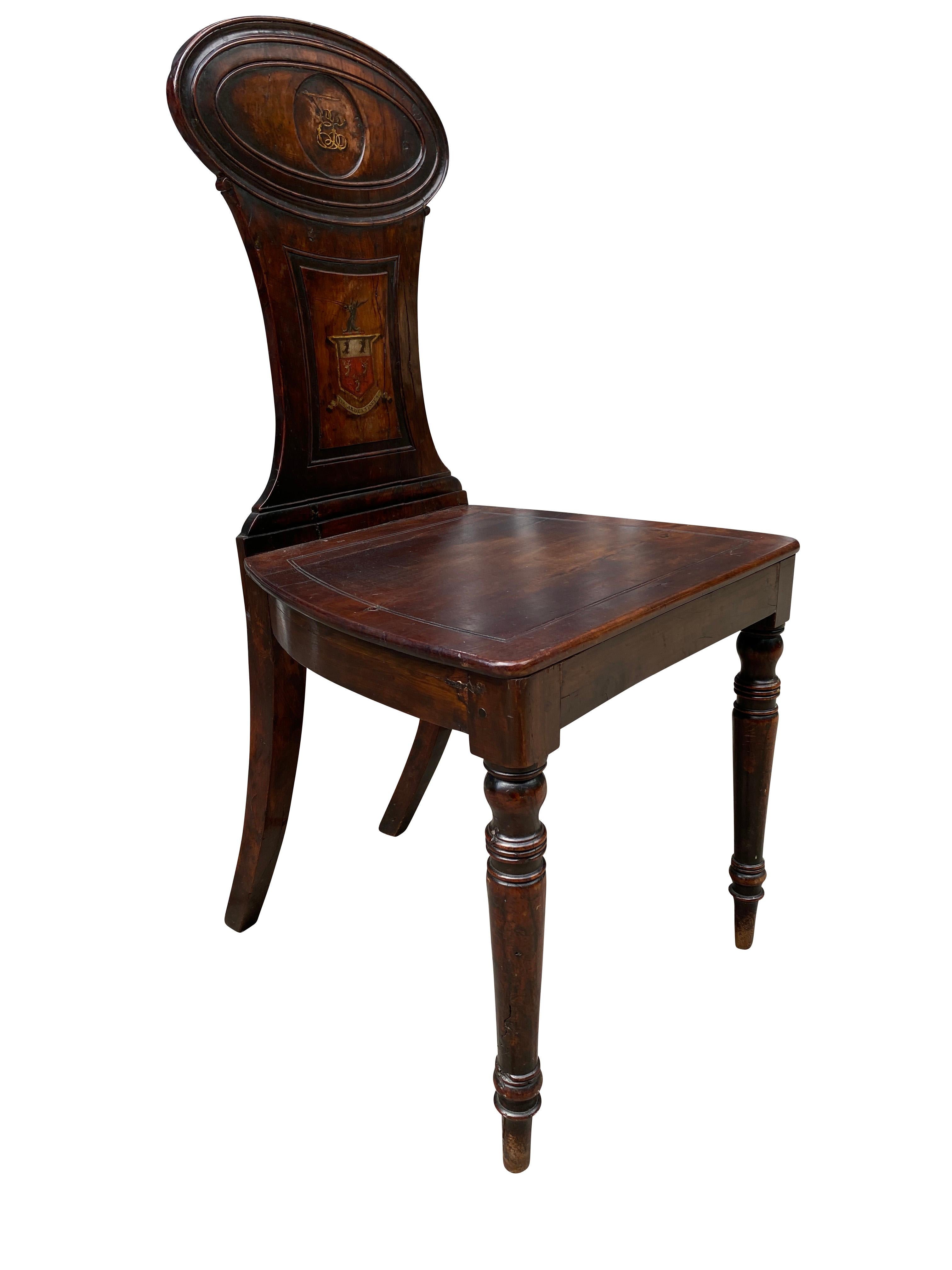 The chair back with oval crest with painted monogram over a tapered splat with coat of arms , wood seat raised on circular tapered legs. From the Estate Of Drue Heinz. Sutton Place. NYC.