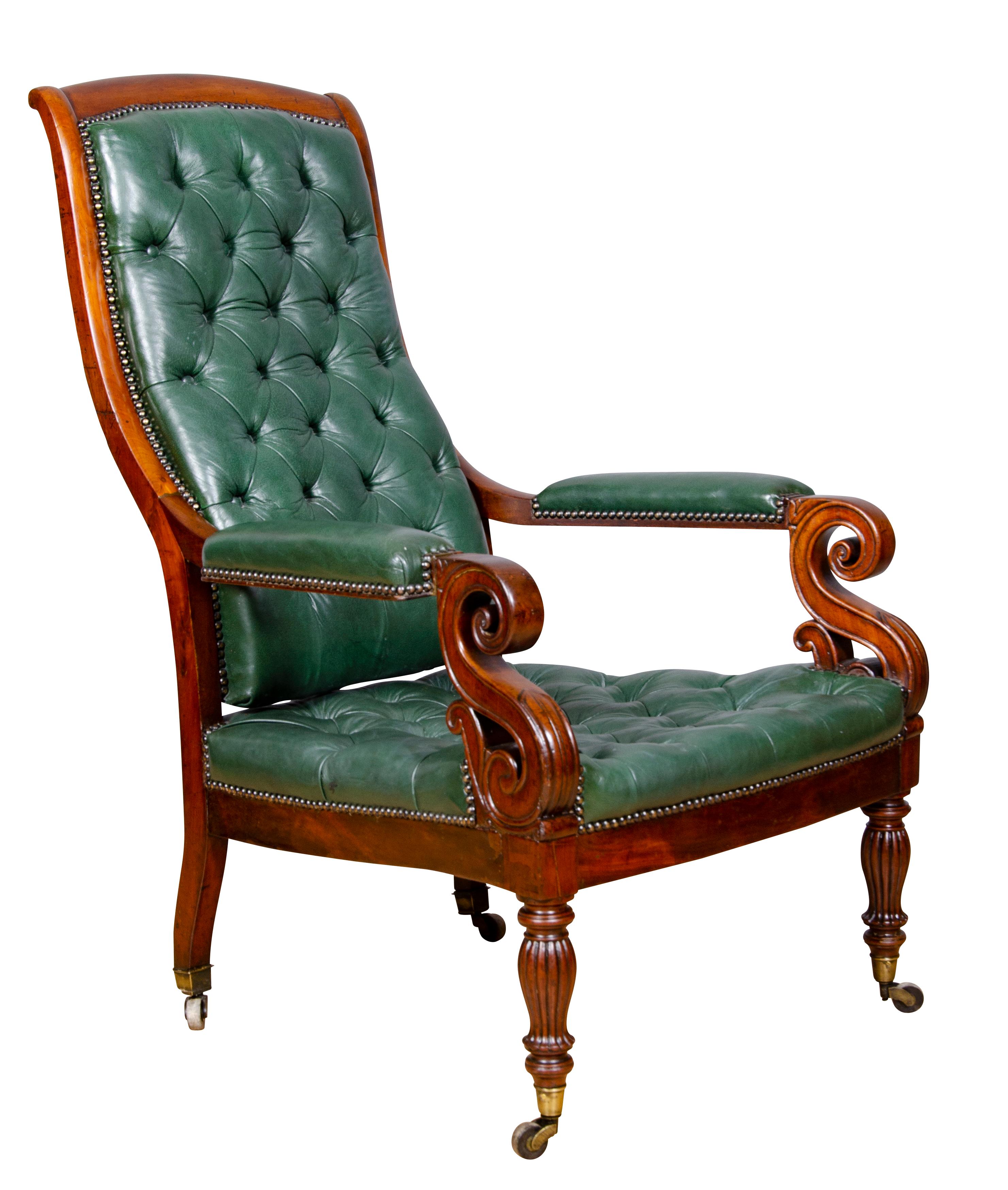 With slightly arched tufted green leather back and matching seat, the handsomely scrolled arms with carved leaf detail, raised on reeded tapered legs and casters.