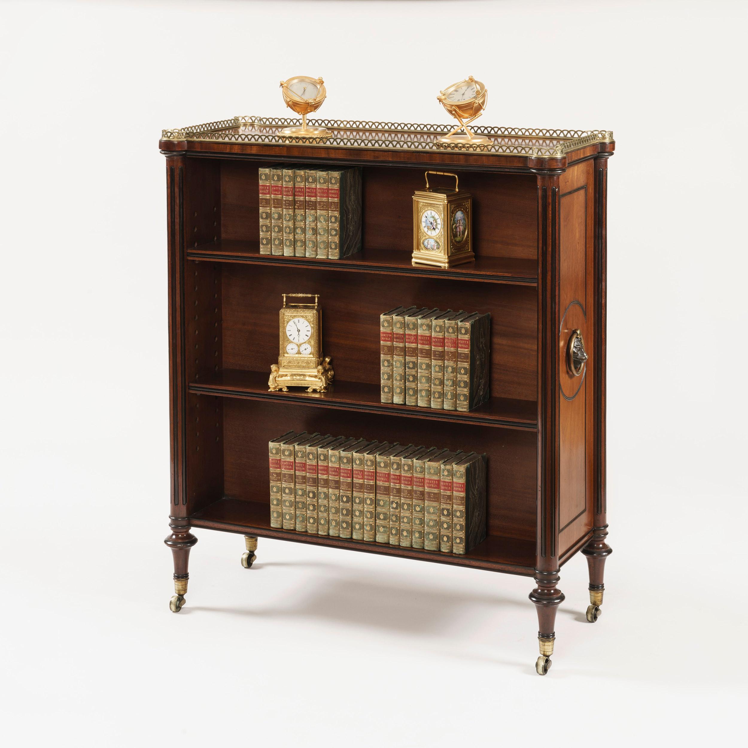 A Regency double-sided bookcase

Constructed in mahogany, with brass adornments; of freestanding form, rising from castor shod ‘cotton reel’ legs, with fluted columns at the angles, each side housing three shelves, and large circular lion’s head