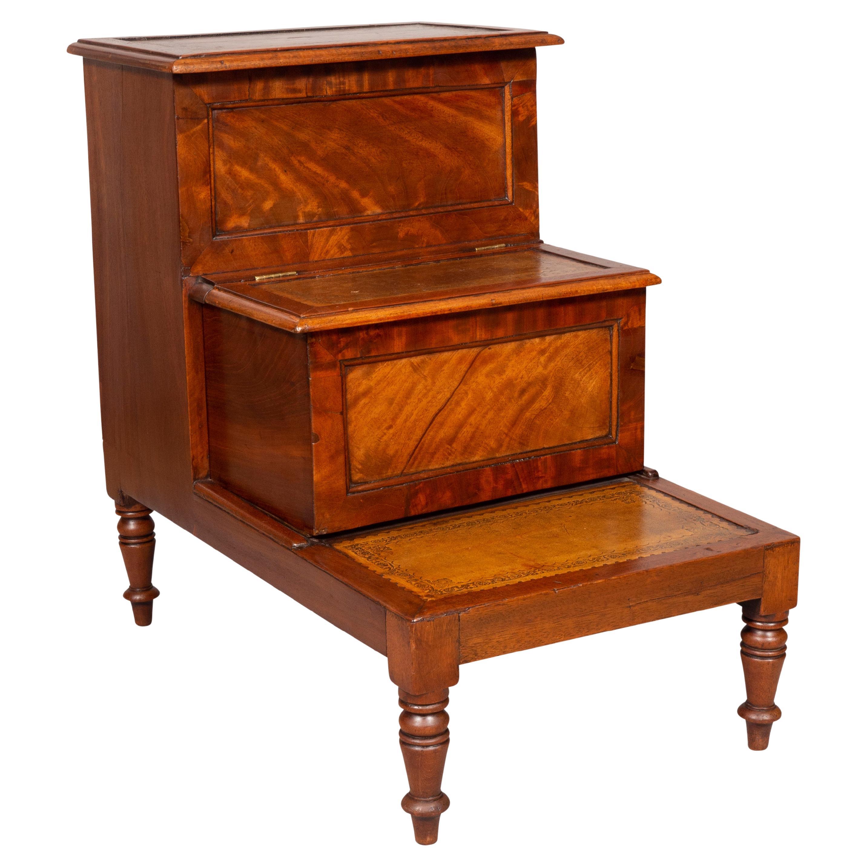 With brown leather steps in a rich mahogany and hidden compartment, raised on turned feet.